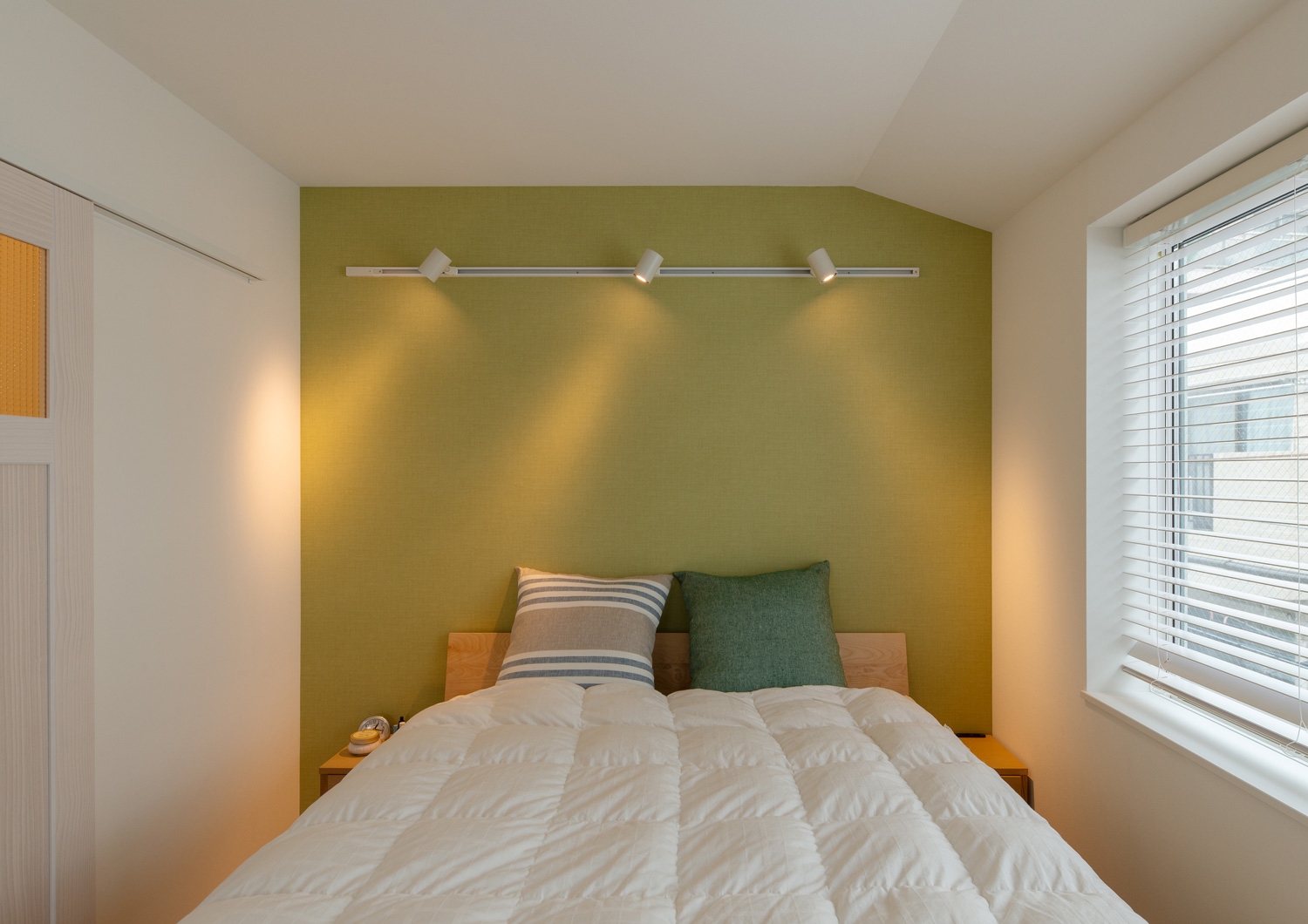 枕やアクセントクロスに緑を採用した寝室・デザイン住宅