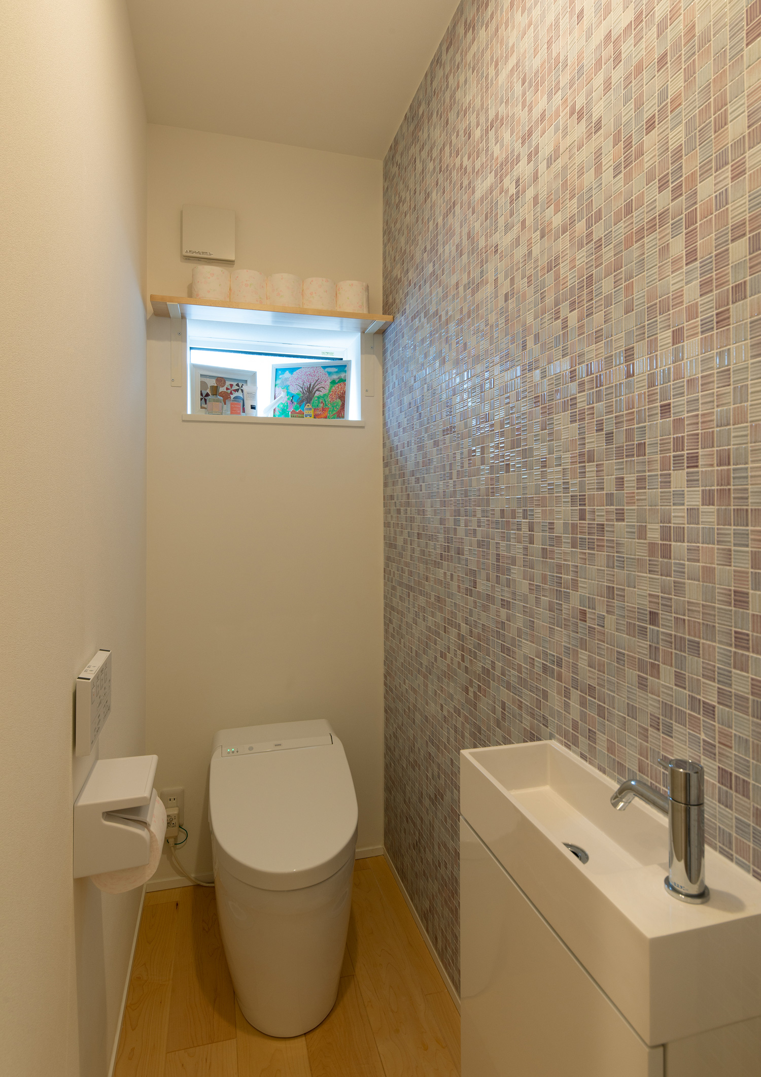 壁にカラフルなタイルを使用した薄型手洗いのあるトイレ・デザイン住宅