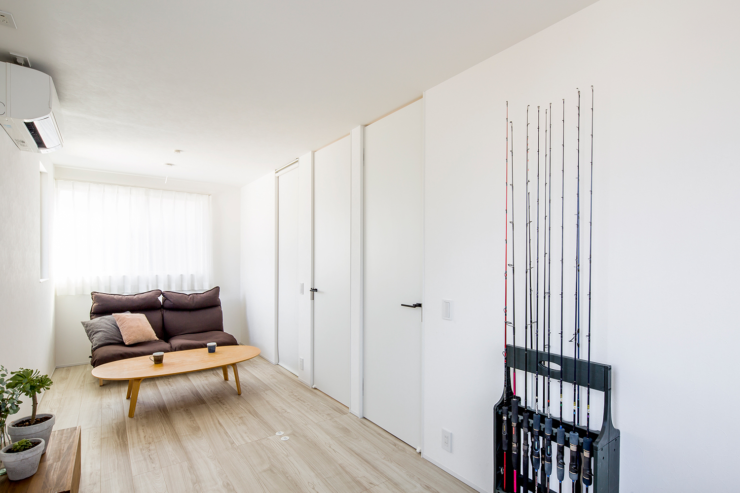 釣り竿を飾るスペースを設けた白い壁のLDK・デザイン住宅