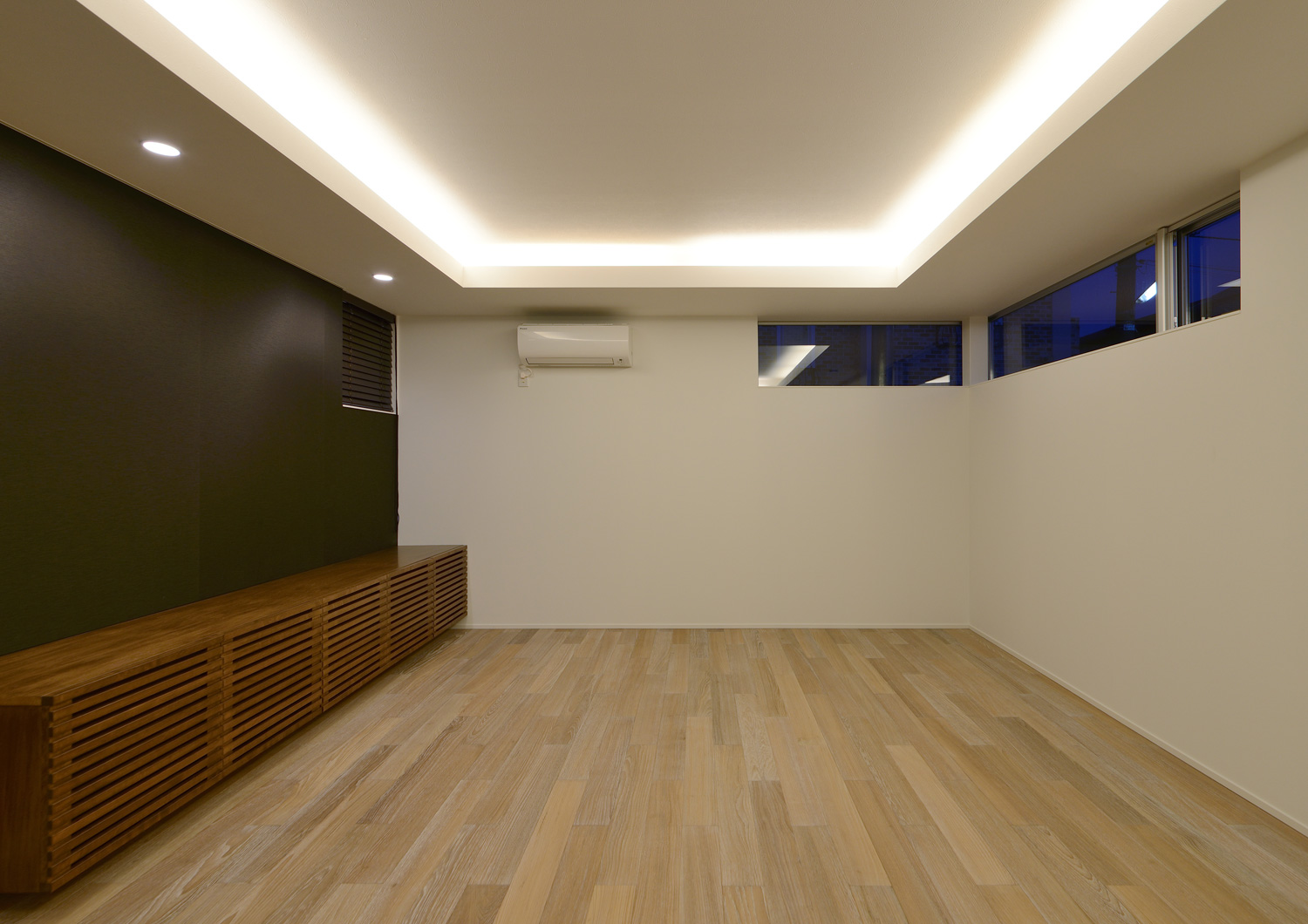 天井の段差を利用して間接照明を取り付けたスリット窓のあるLDK・デザイン住宅