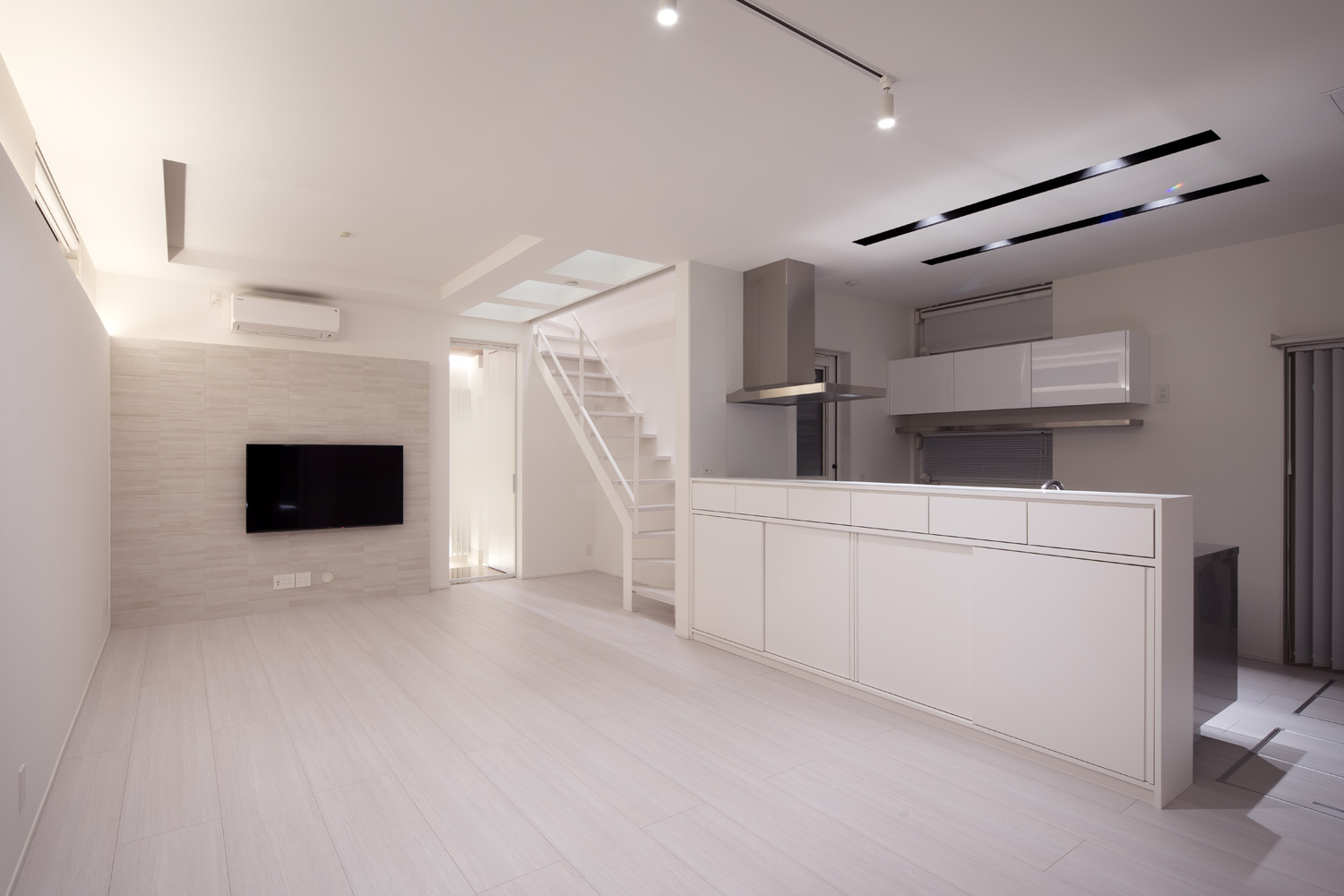 キッチンの天井を掘り込んで照明を取り付けた、真っ白なLDK・デザイン住宅