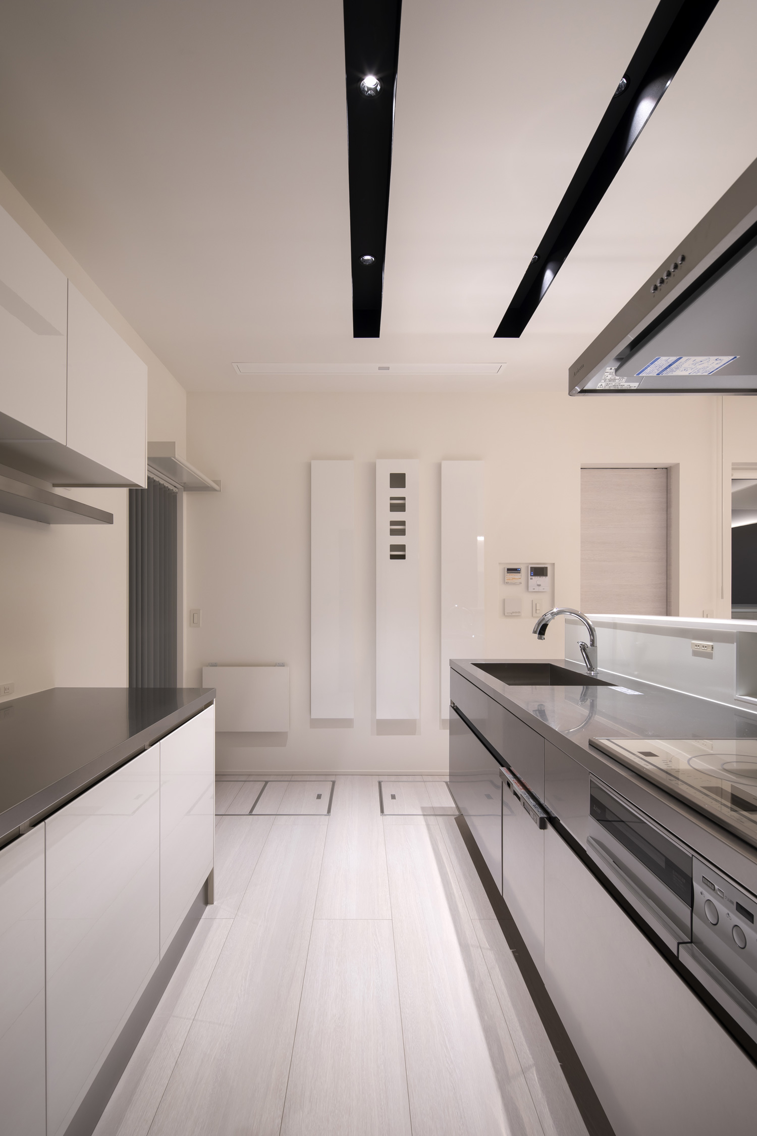 シンクやコンロの背面に作業スペースがある白を基調としたⅡ型キッチン・デザイン住宅