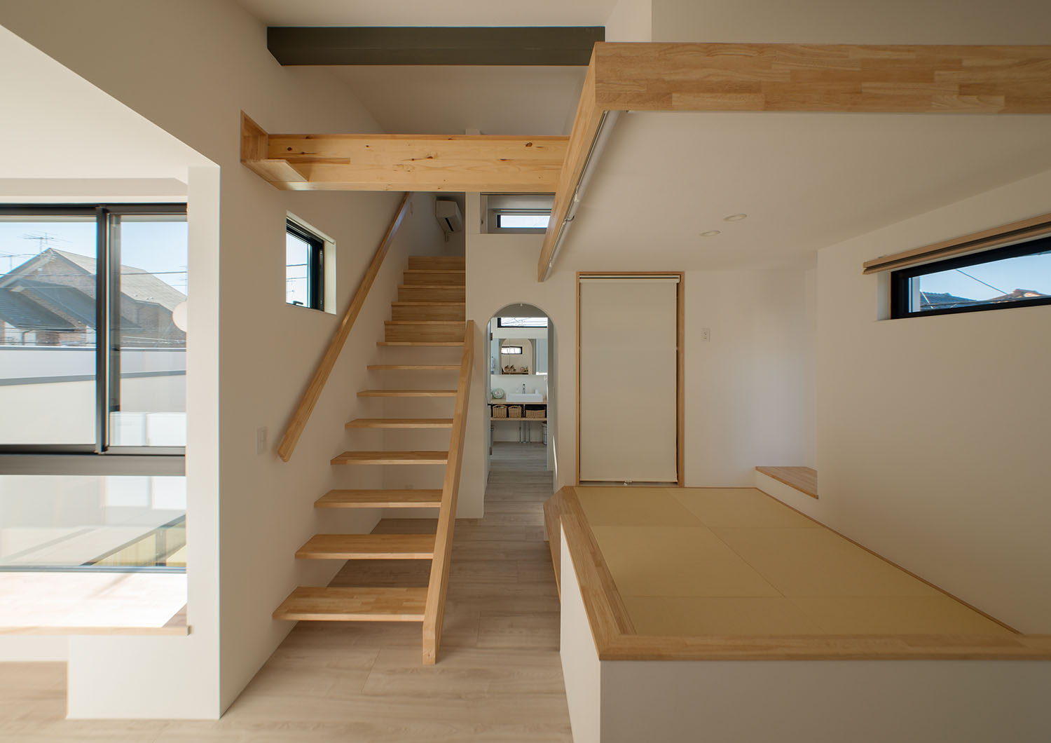 木のスケルトン階段のそばに和室がある様子・デザイン住宅