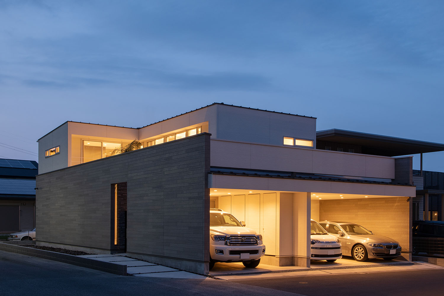 三台の車が入るインナーガレージの内部に照明が取り付けられている様子・デザイン住宅