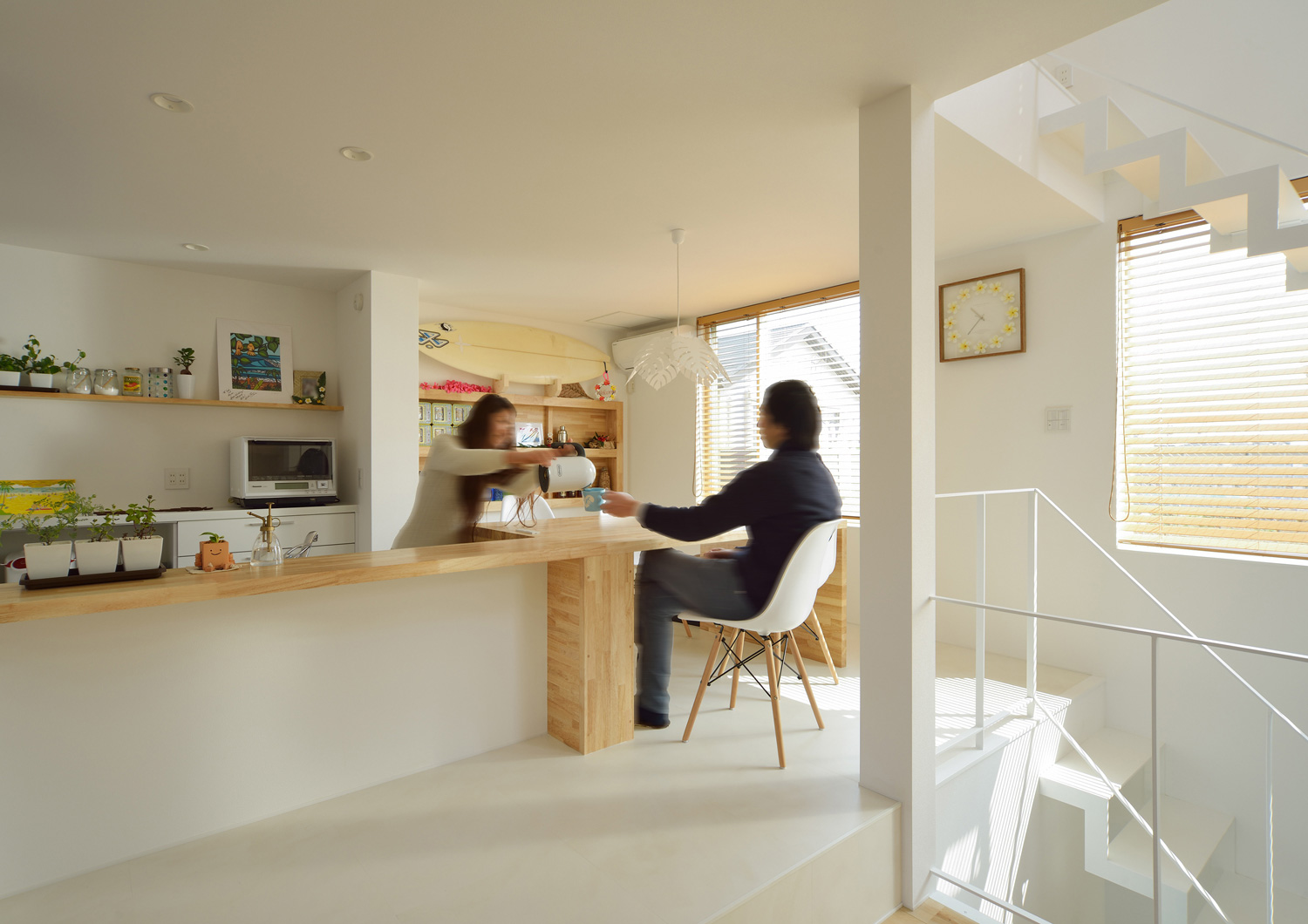 キッチンと一体型になった木のダイニングテーブルがあるシンプルなLDK・デザイン住宅