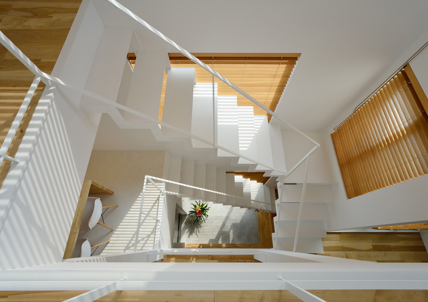 螺旋階段になった吹き抜けの階段室を上から見た様子・デザイン住宅