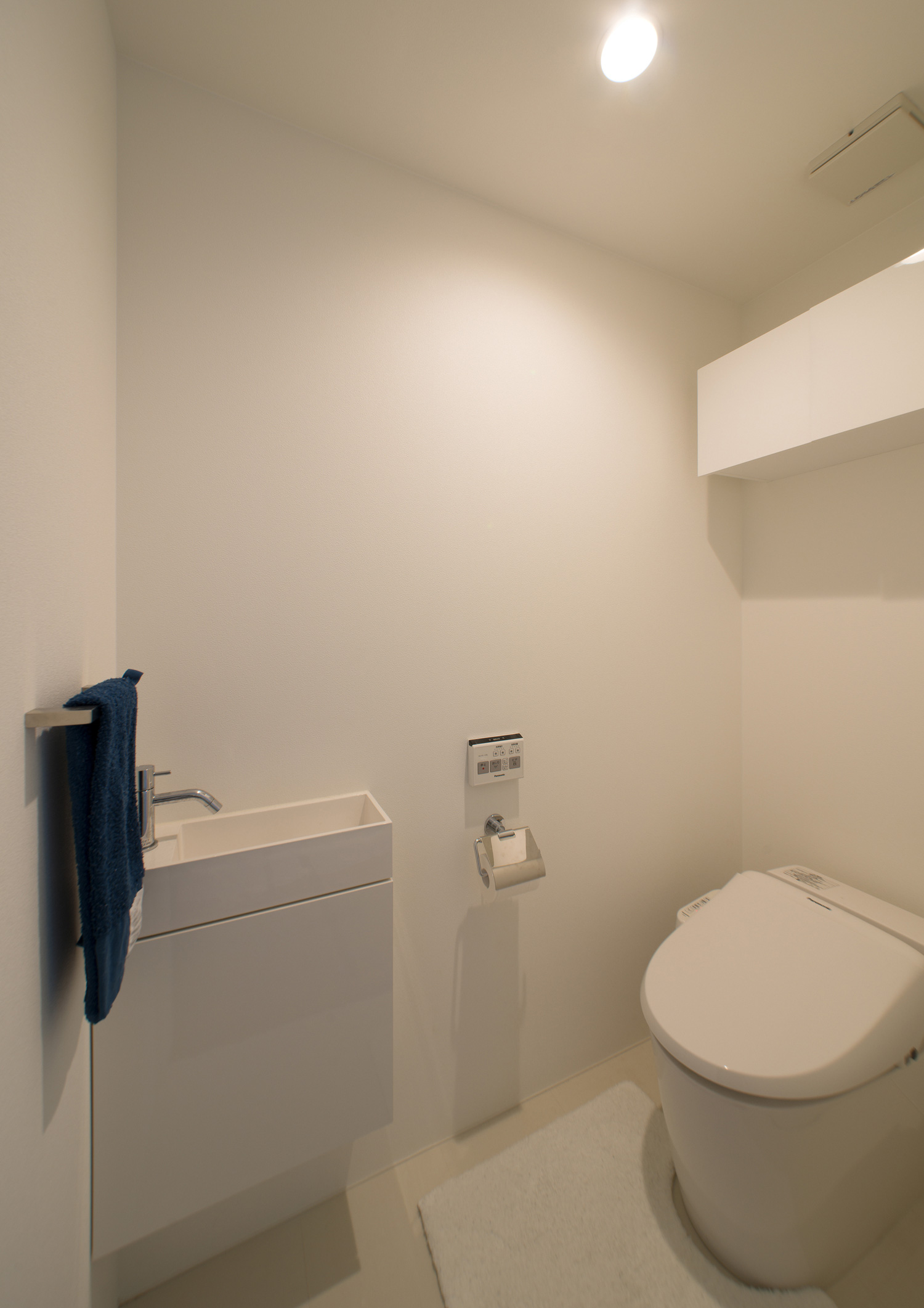 収納や薄型手洗いを白で統一したトイレ・デザイン住宅