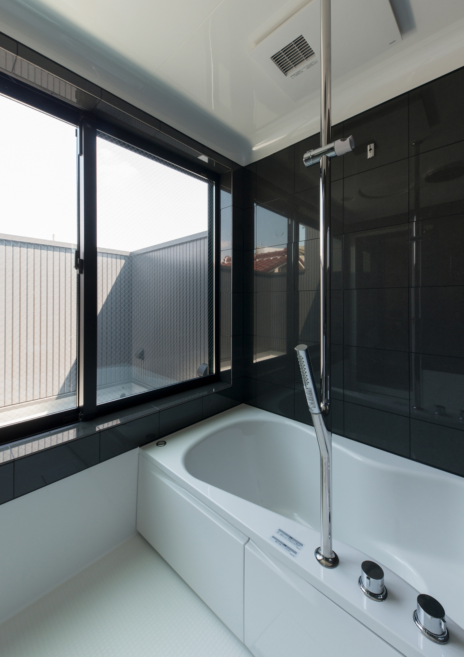 黒い壁でバルコニーに面した窓がある浴室・デザイン住宅