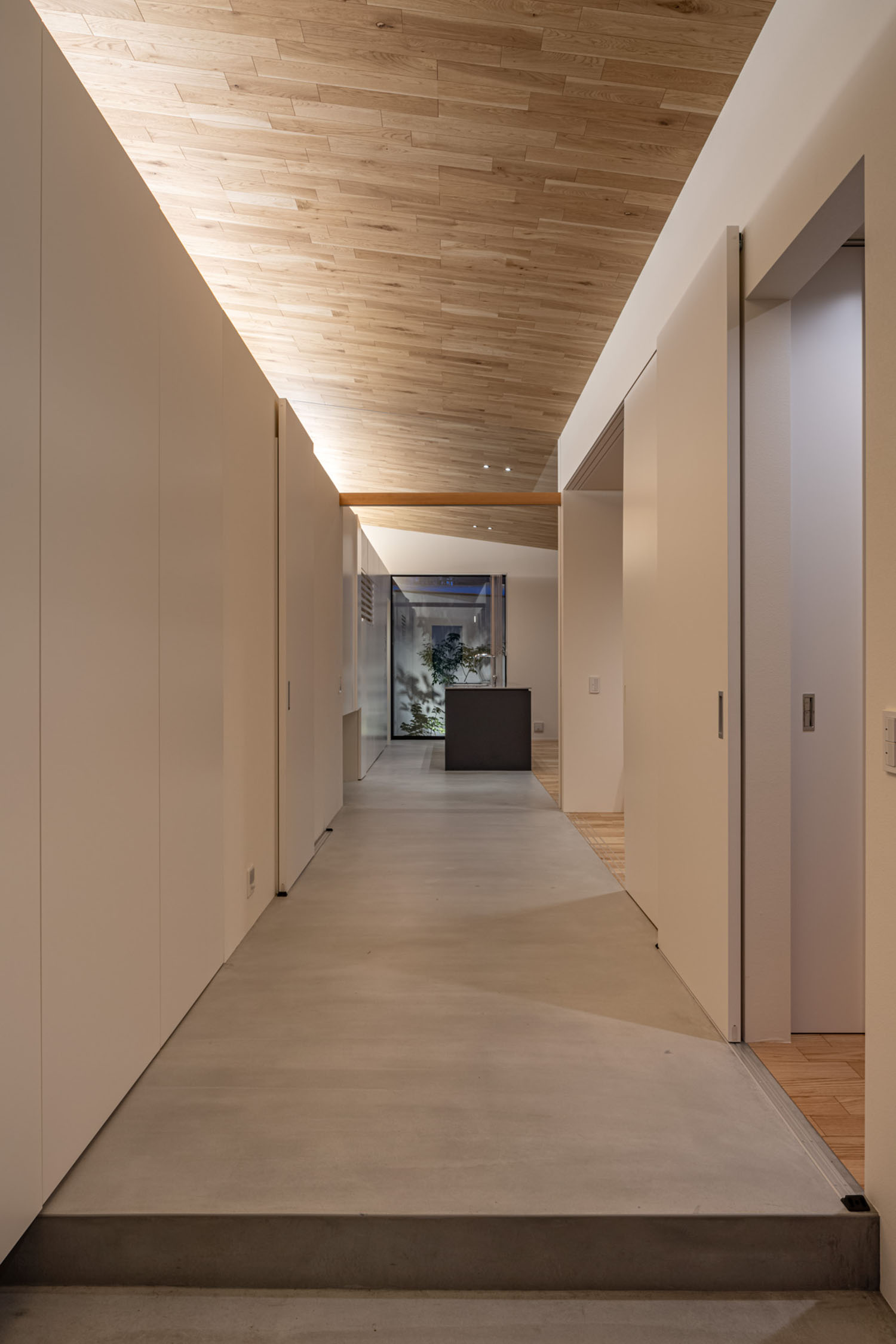 木目の天井とモルタルの床の廊下・デザイン住宅