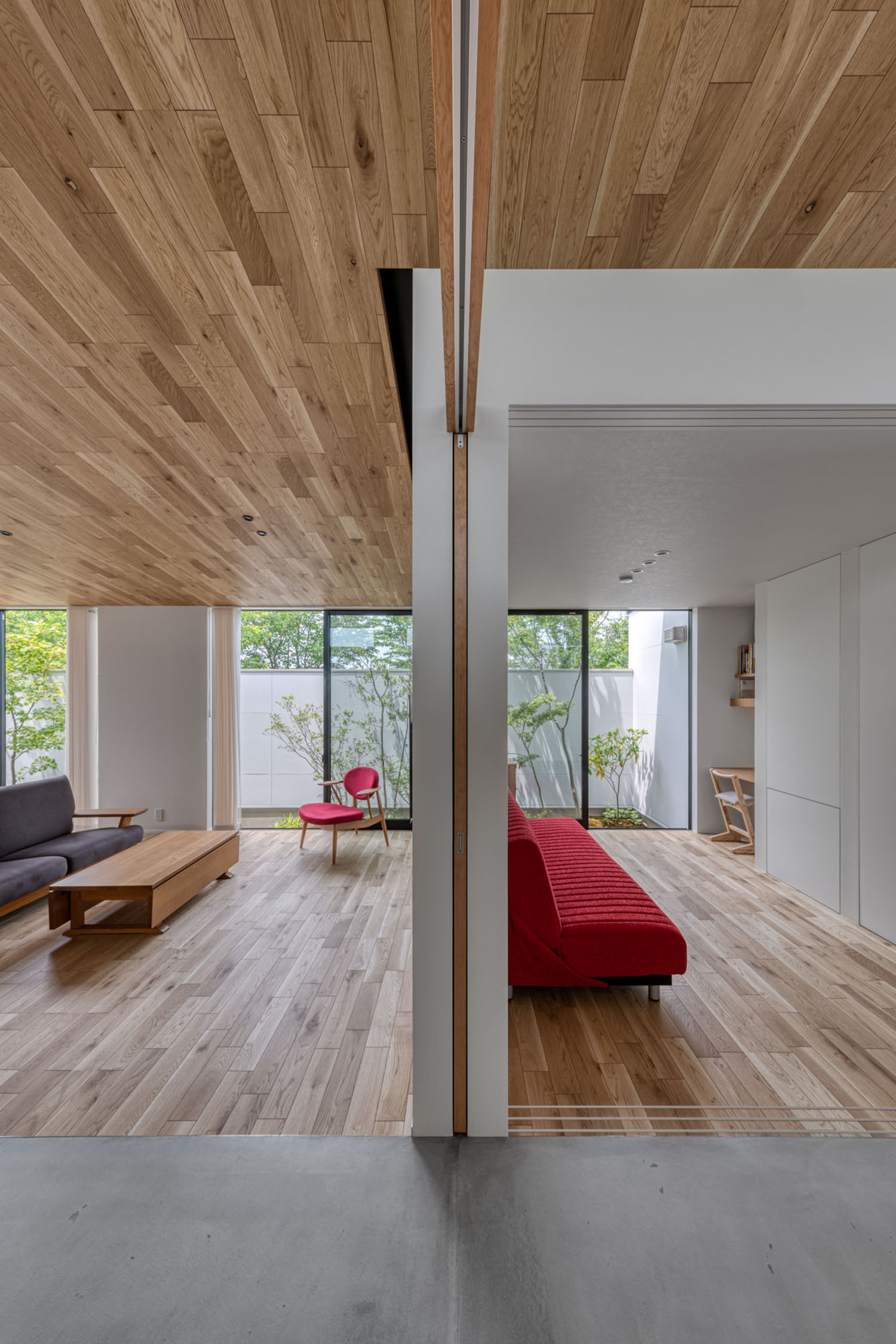 床や天井に木材を使用したLDKが引き戸で仕切られている様子・デザイン住宅