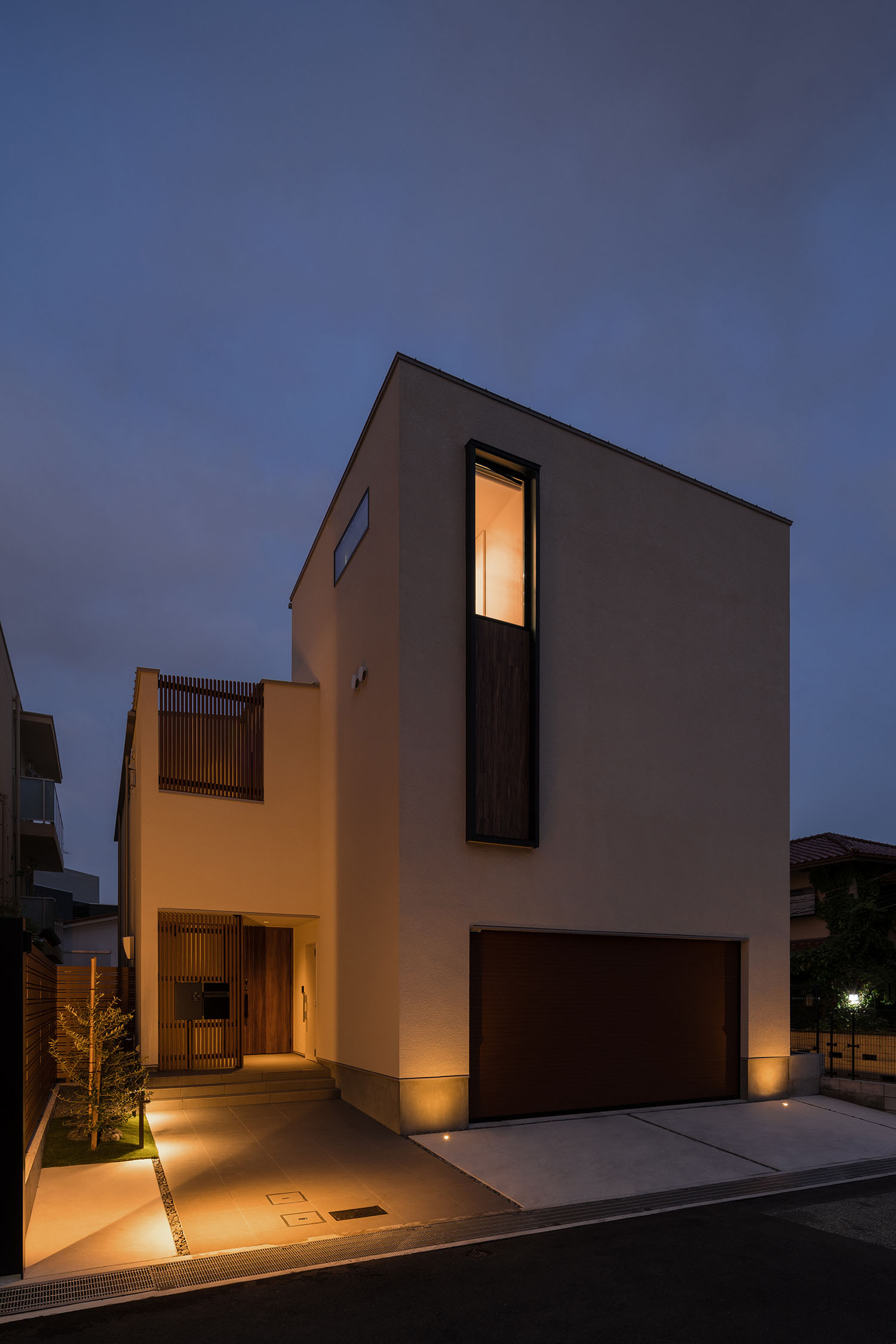 屋外照明によって玄関アプローチが照らされる住宅の外観・デザイン住宅