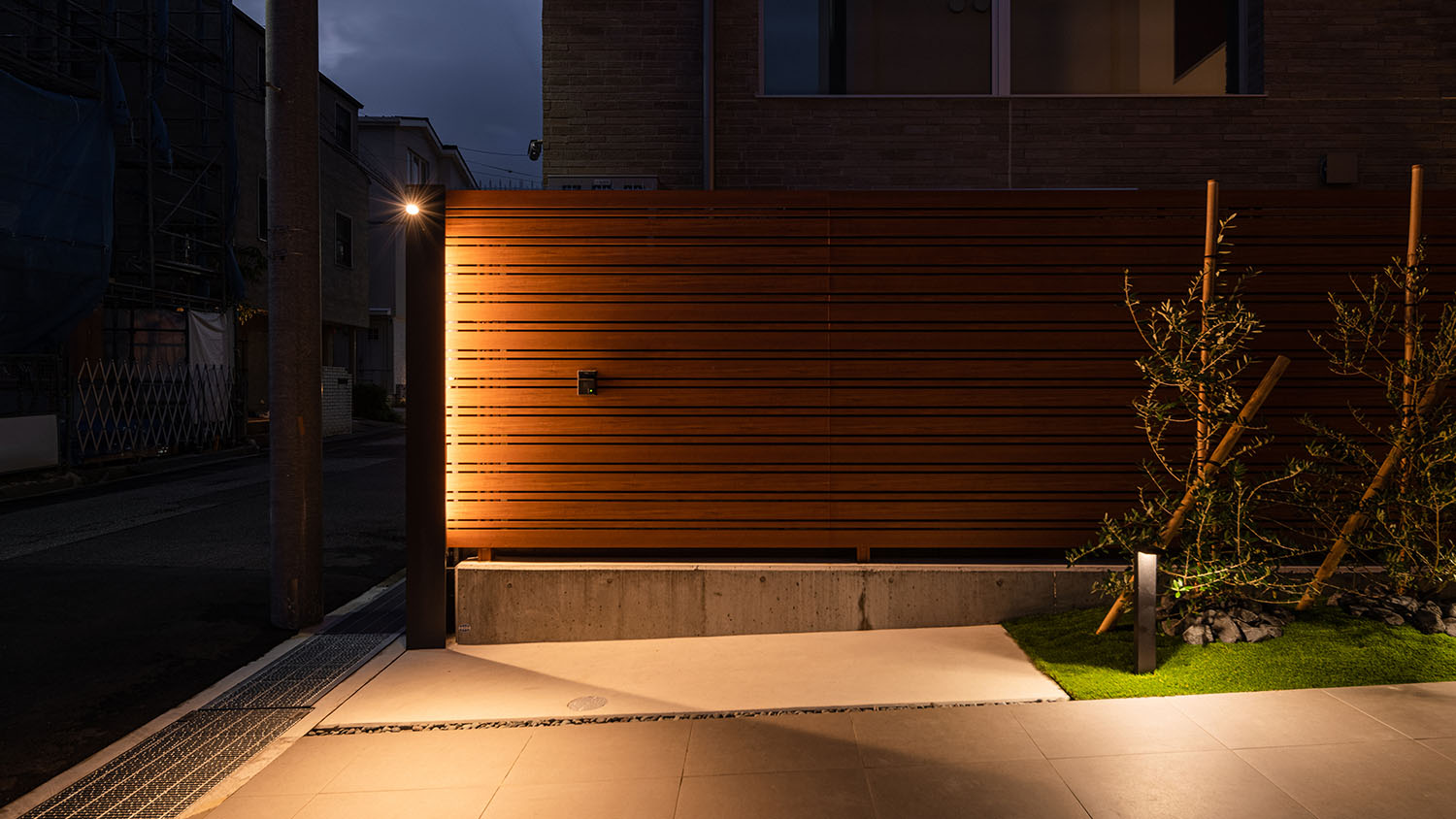 間接照明によって木の外構が照らされる住宅の外観・デザイン住宅