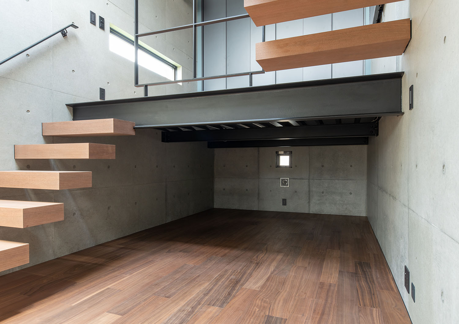 木製の浮いているような階段がスキップフロアを繋いでいるLDK・デザイン住宅