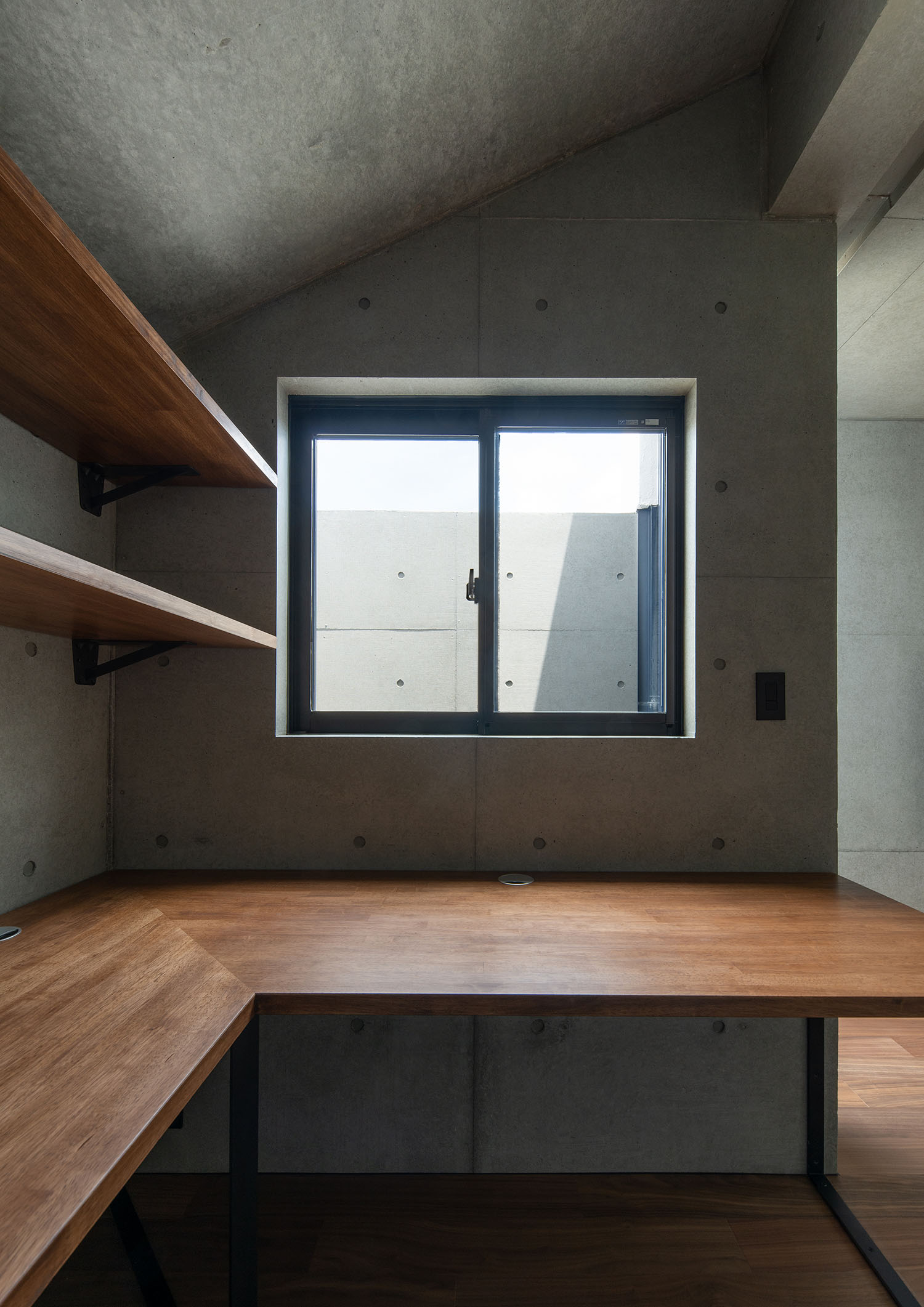壁付けの木のデスクがある空間に設けられた窓・デザイン住宅