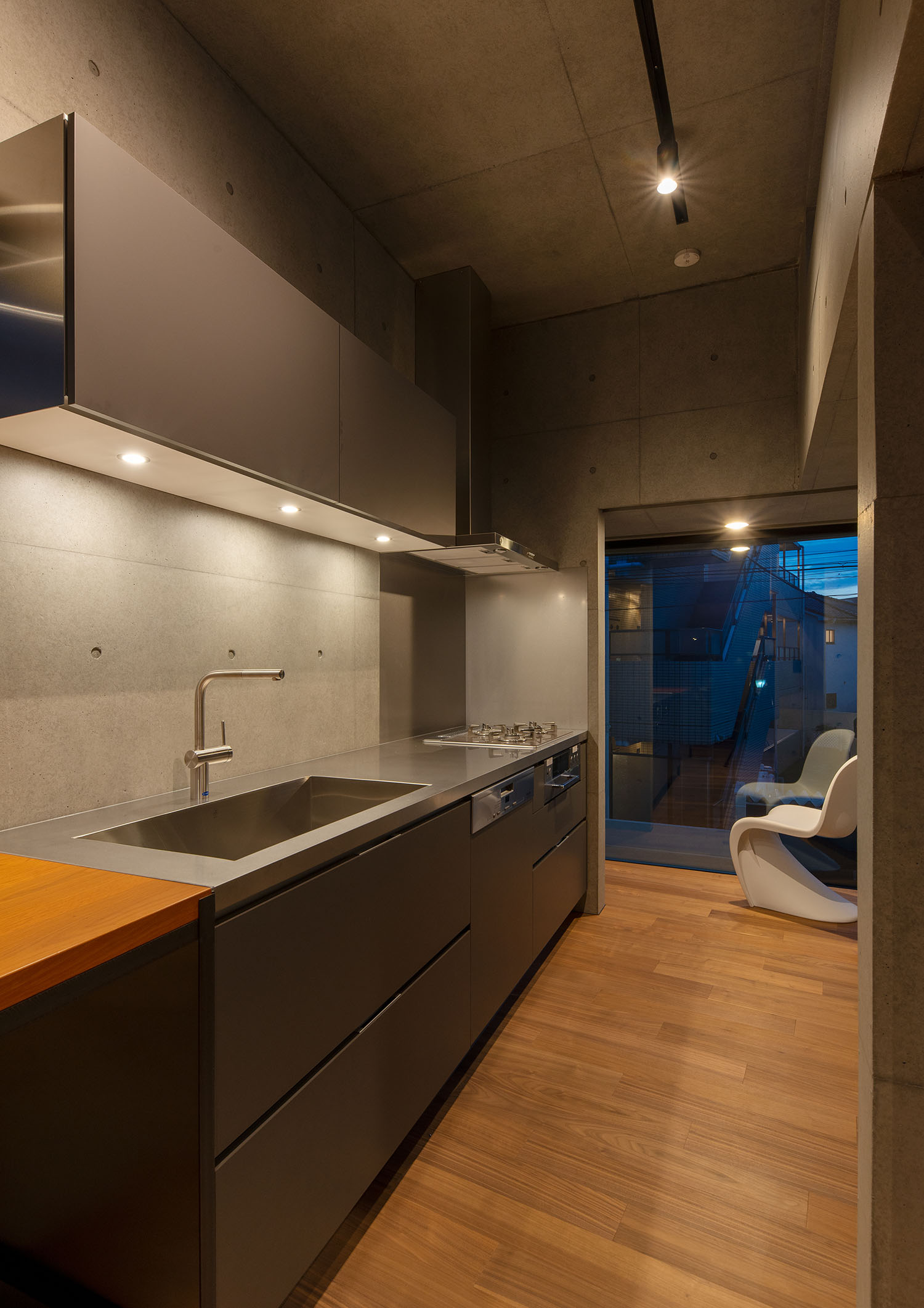 壁付けキッチン上部の収納棚にあるダウンライトがキッチンを照らす・デザイン住宅