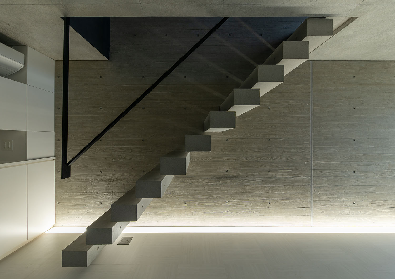 コンクリートのスケルトン階段が間接照明によって照らされている・デザイン住宅