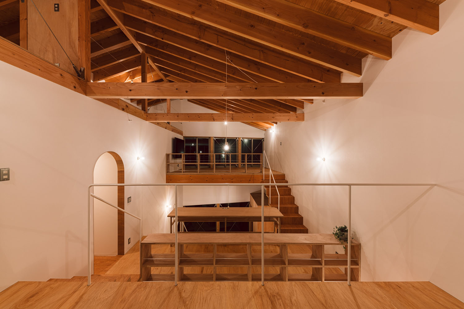 間接照明によって照らされる梁見せ天井のスキップフロア・デザイン住宅