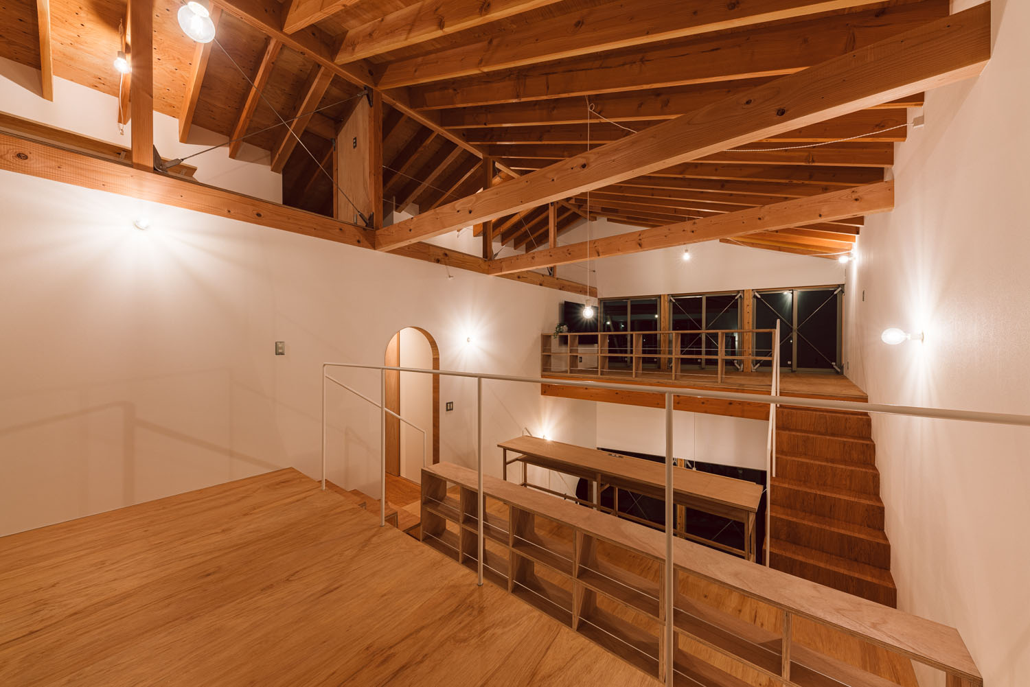 間接照明によって照らされる梁見せ天井のスキップフロア・デザイン住宅