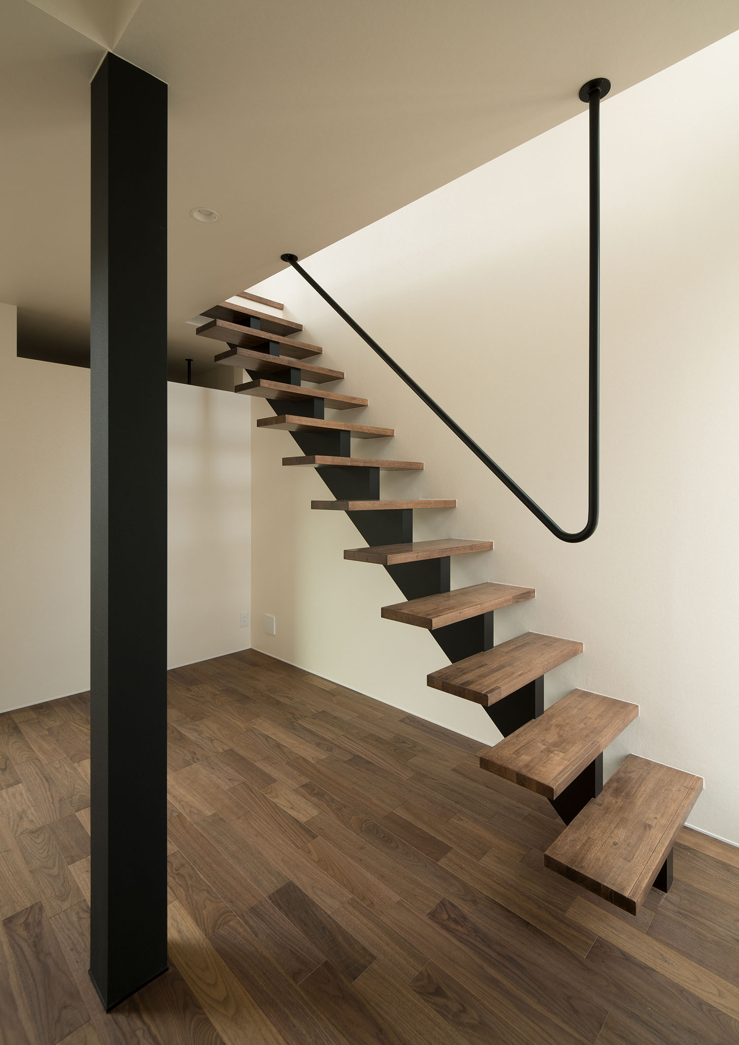 アイアンの手すりが天井に取り付けられた木製のスケルトン階段・デザイン住宅
