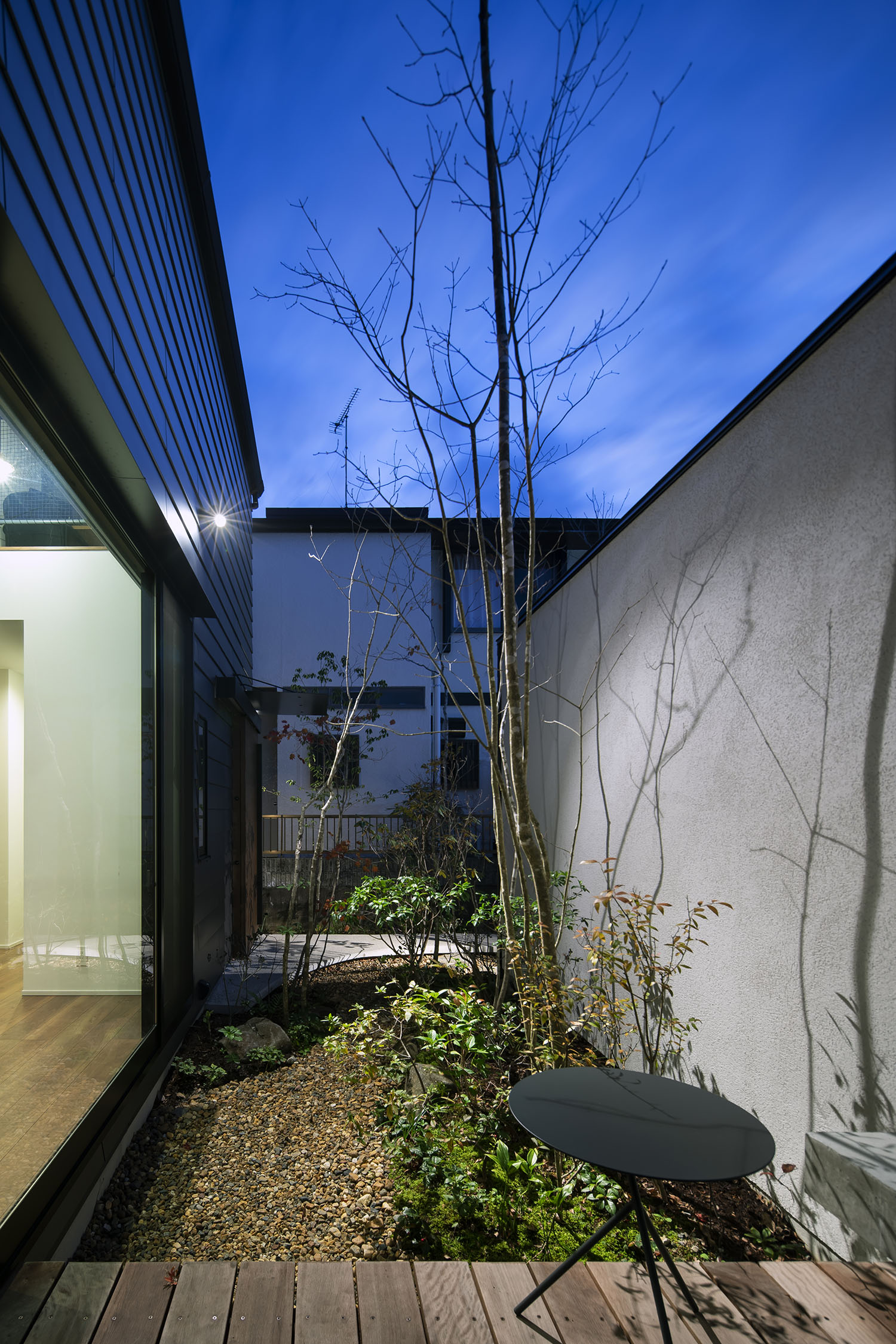 ウッドデッキのテラスから植栽や玄関アプローチを見通す様子・デザイン住宅
