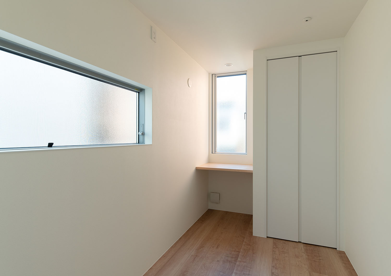 スリット窓と壁付けのデスクが設けられた個室・フリーダムアーキテクツの事例