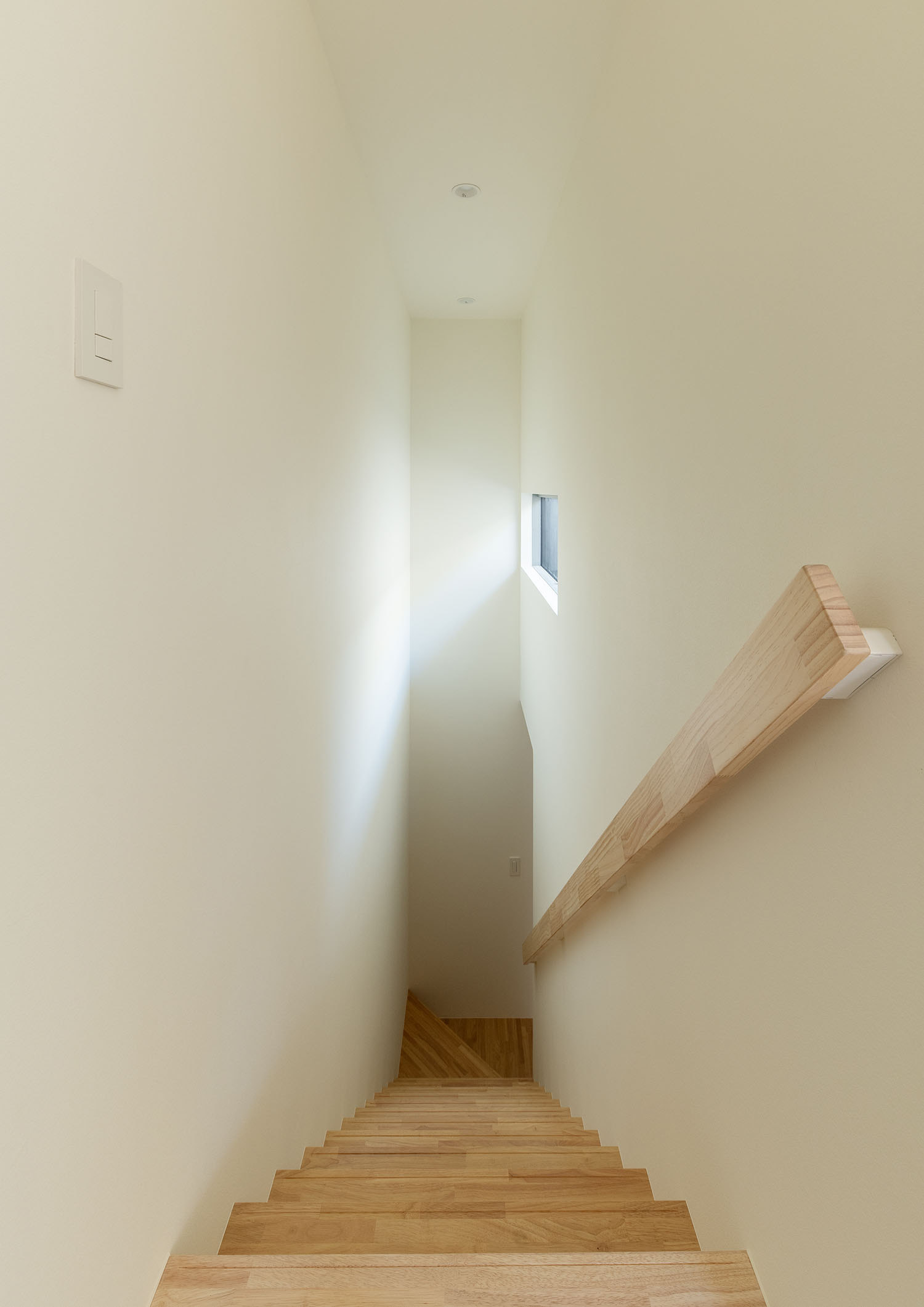 スリット窓から自然光が入る木製の箱型階段・フリーダムアーキテクツの事例