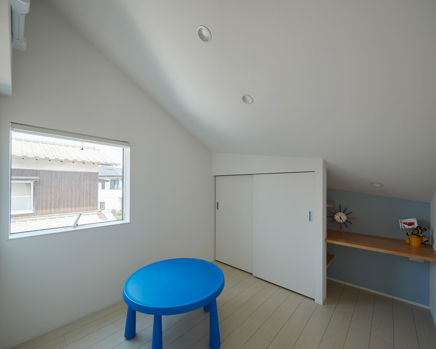 アクセントクロスとテーブルが青で統一された子供部屋・フリーダムアーキテクツの事例