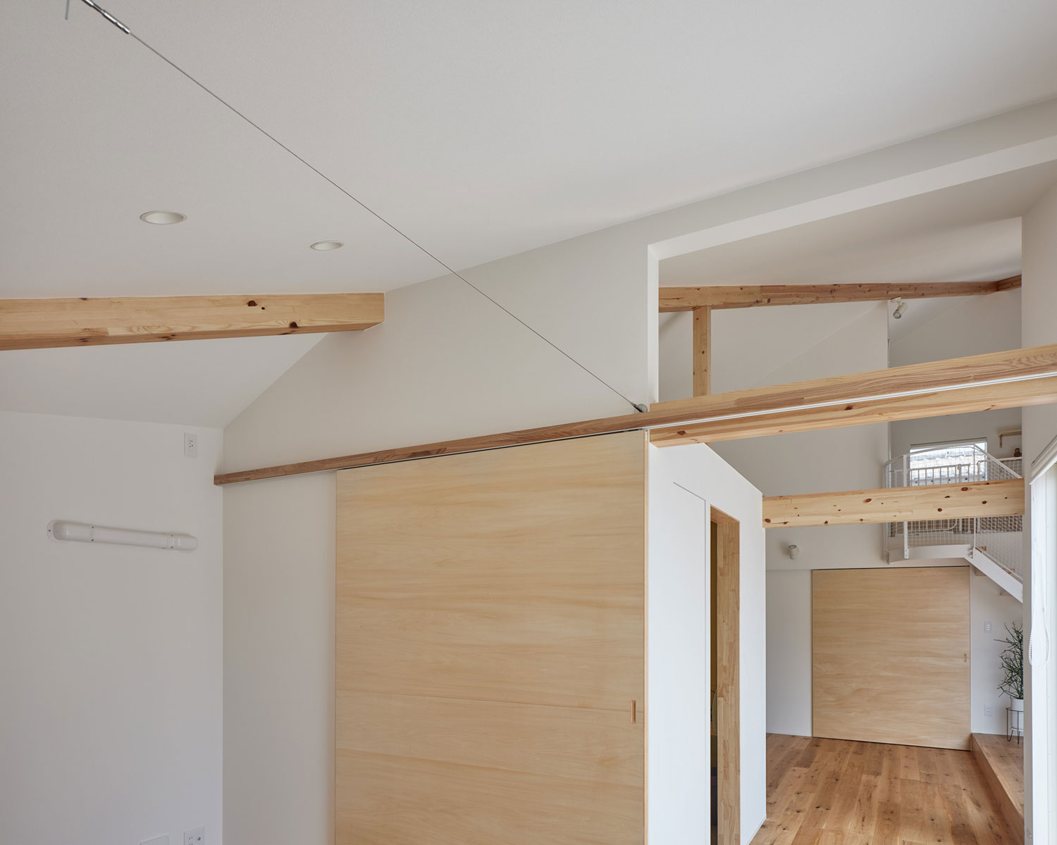 木材の梁を見せ、扉に木材を使用した空間・フリーダムアーキテクツの事例