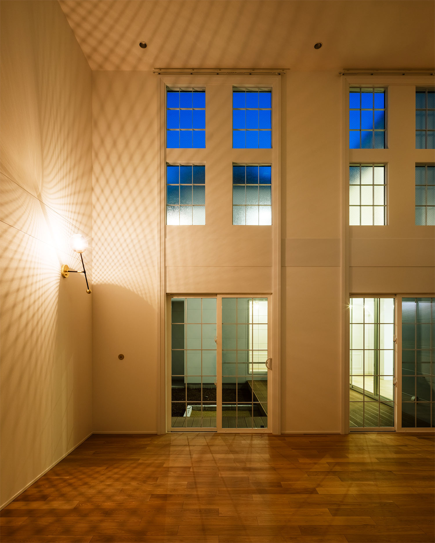 照明の影がリビングの白い壁に映し出されている・フリーダムアーキテクツの事例