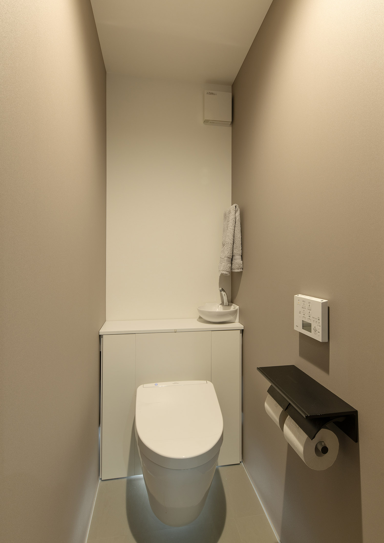 手洗いカウンターを設けた、白を基調としたトイレ・フリーダムアーキテクツの事例
