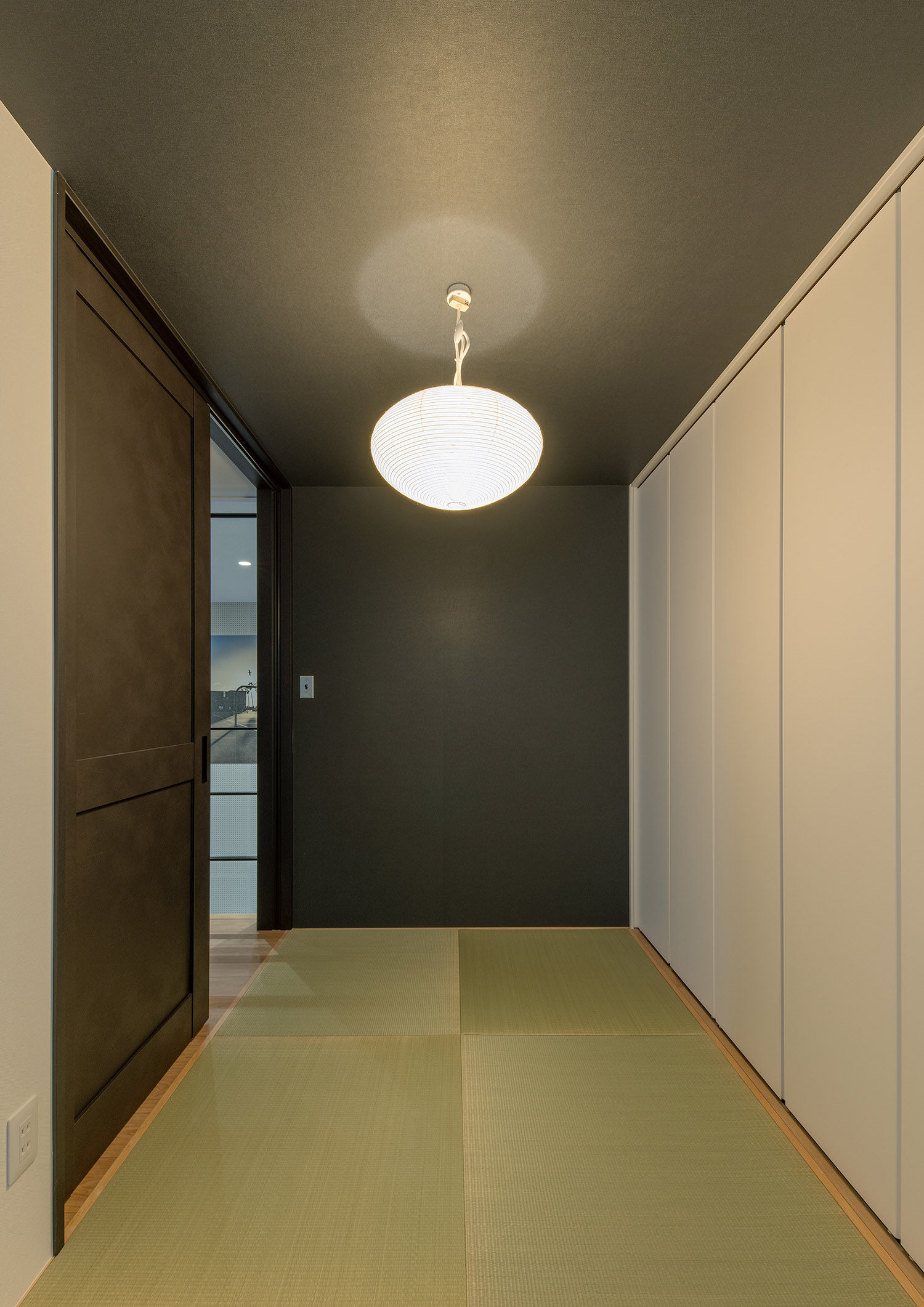 琉球畳が敷かれ、丸い間接照明がある和室・フリーダムアーキテクツの事例