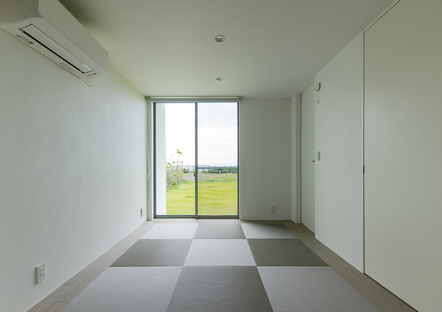 芝生が見える窓が取り付けられた琉球畳の和室・デザイン住宅