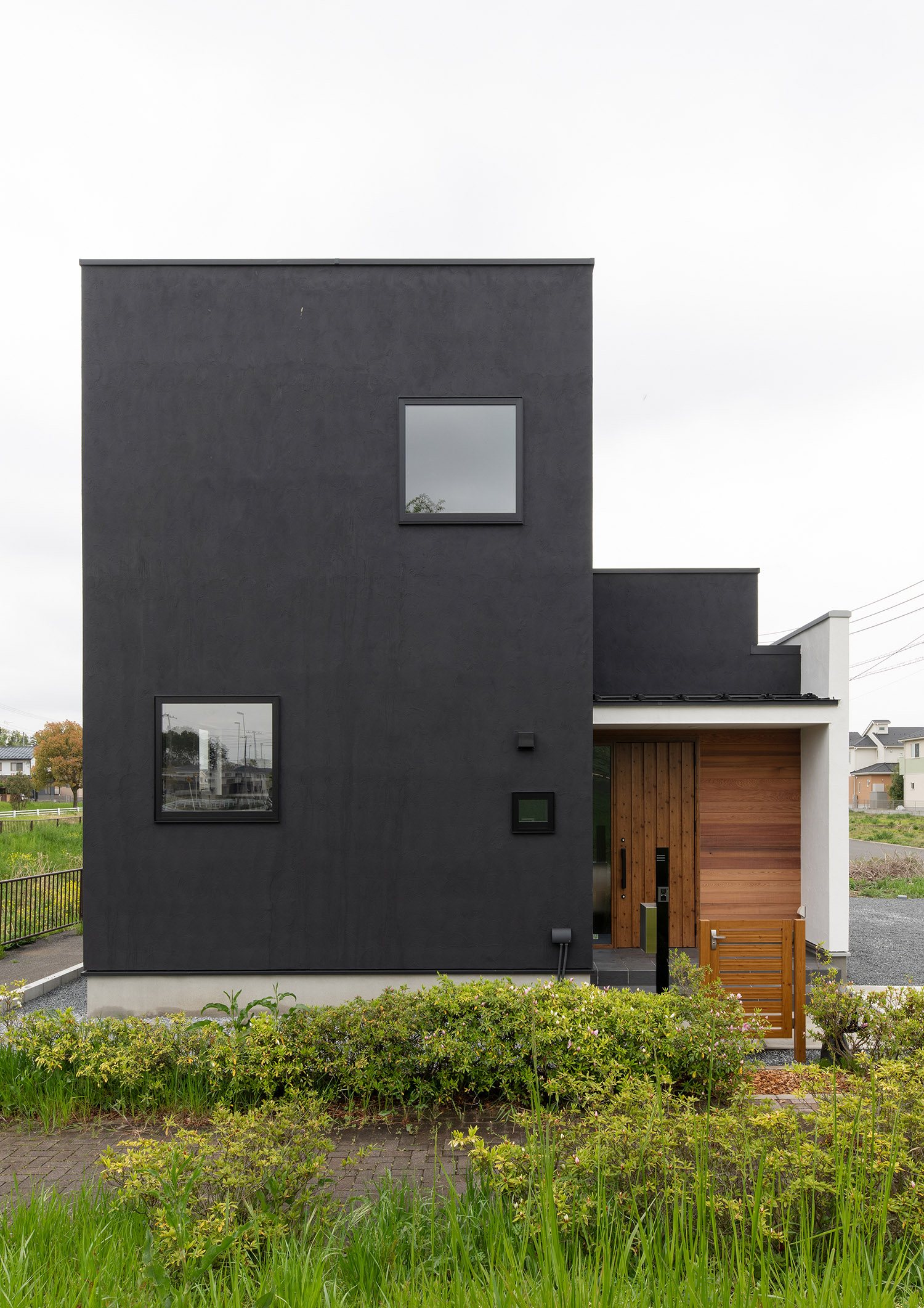 黒い外壁で、壁の一部に木を使った住宅・デザイン住宅