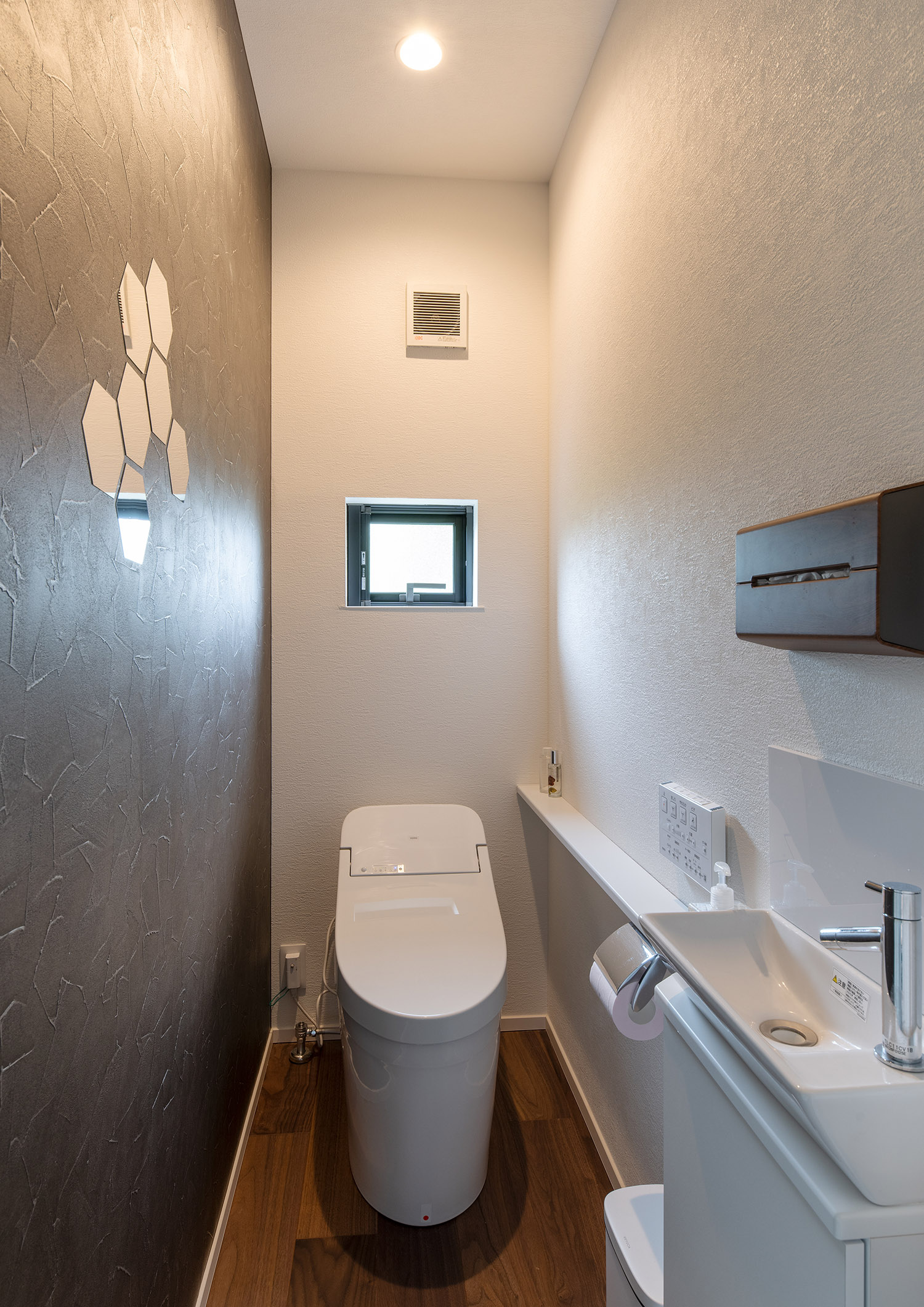 小さな窓が取り付けられた薄型手洗いのあるトイレ・デザイン住宅