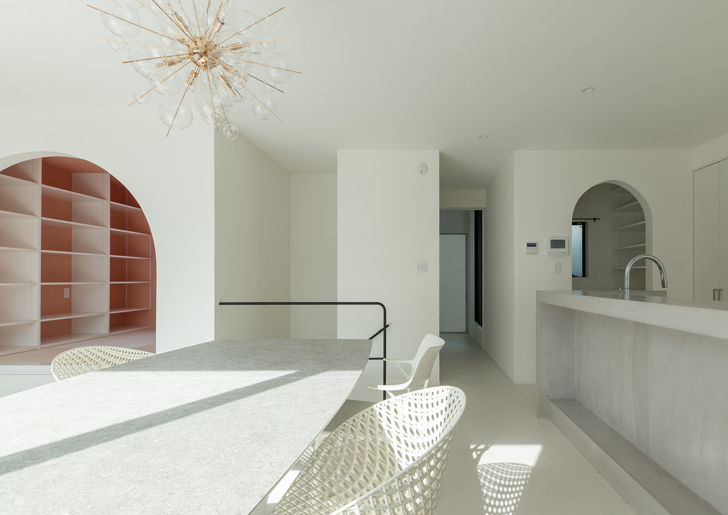 グレーのカウンターキッチンとダイニングテーブルがある白を基調としたLDK・デザイン住宅