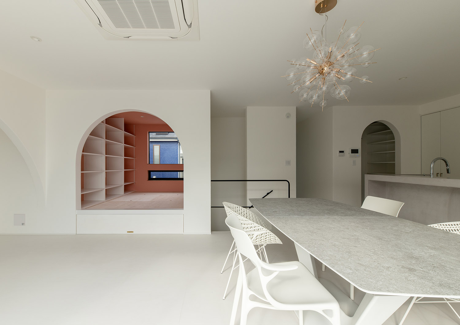 アーチ壁で仕切られた小上がりのスペースがある白を基調としたLDK・デザイン住宅