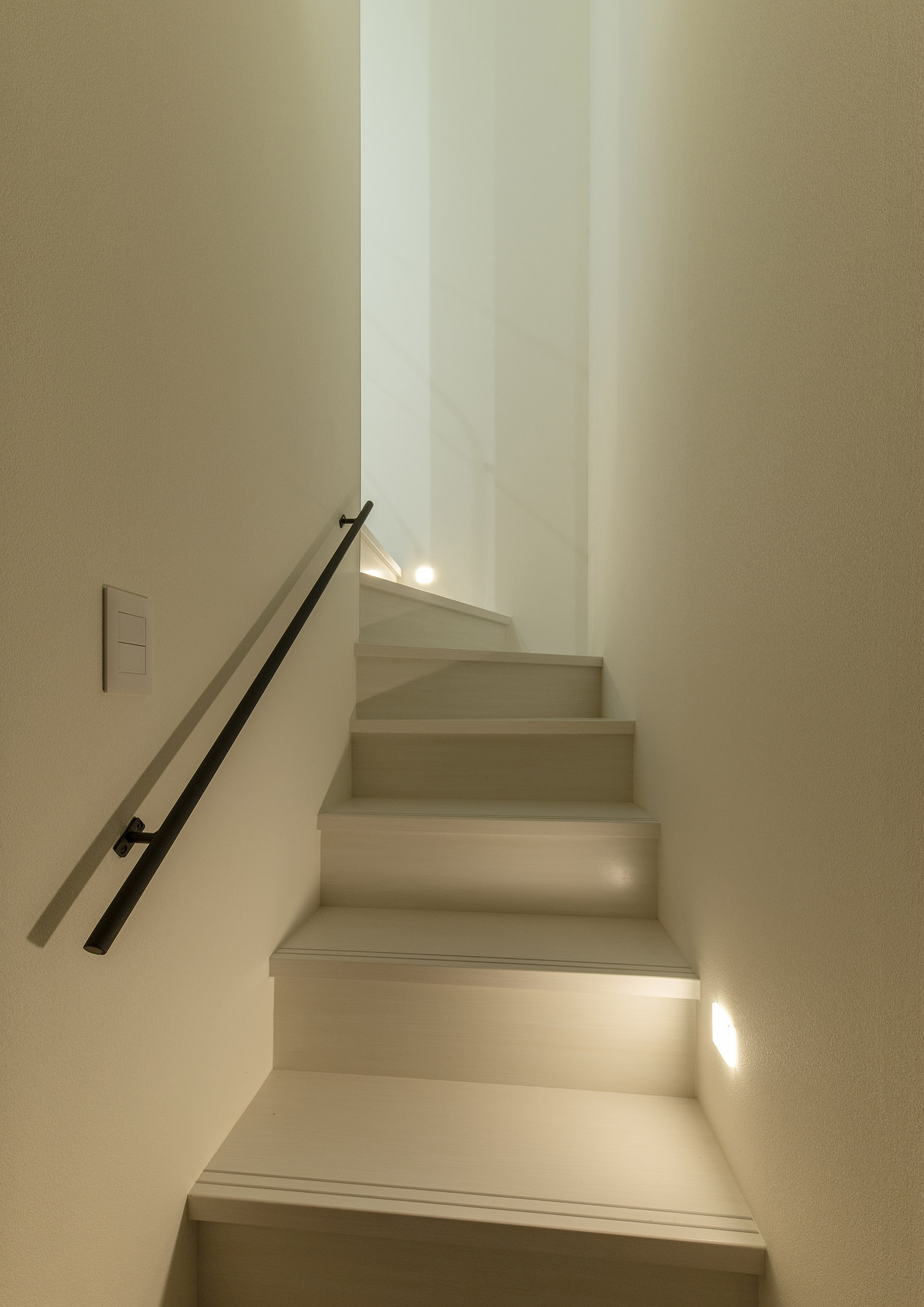 足元に照明を取り付けた白い箱型階段・デザイン住宅