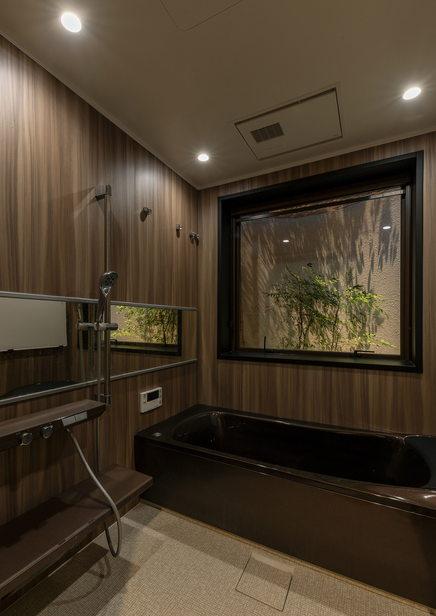 木目風の壁で、窓から植栽が見える浴室・デザイン住宅