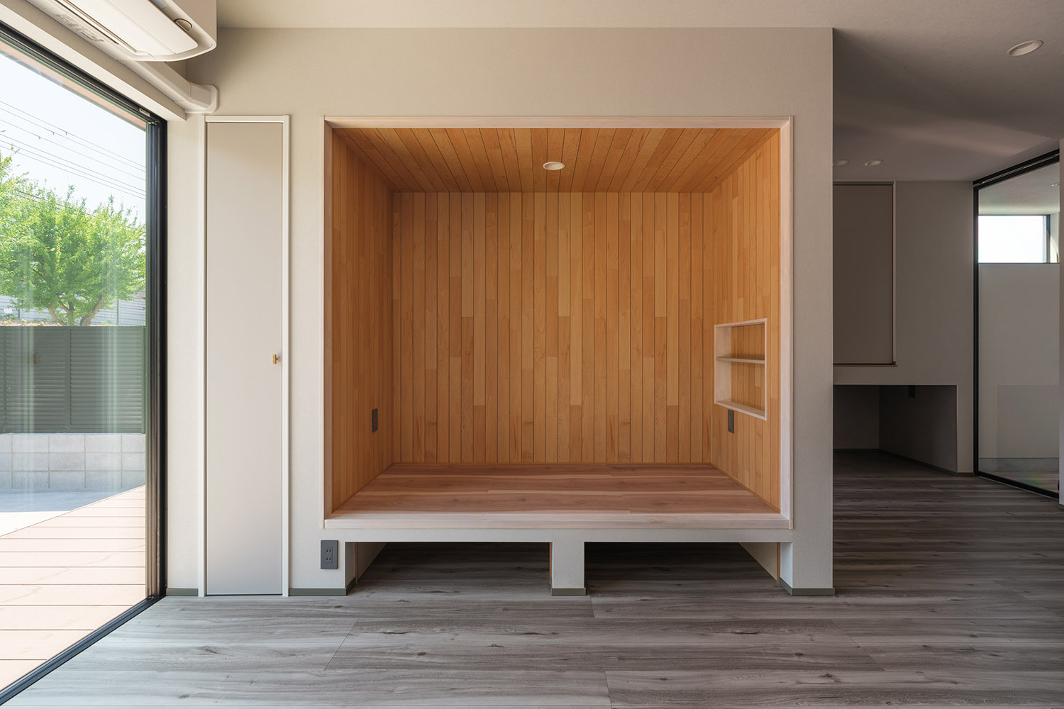 壁をくりぬいてベンチのようにし、全面に木材を使用したLDKにある造作ベンチ・デザイン住宅