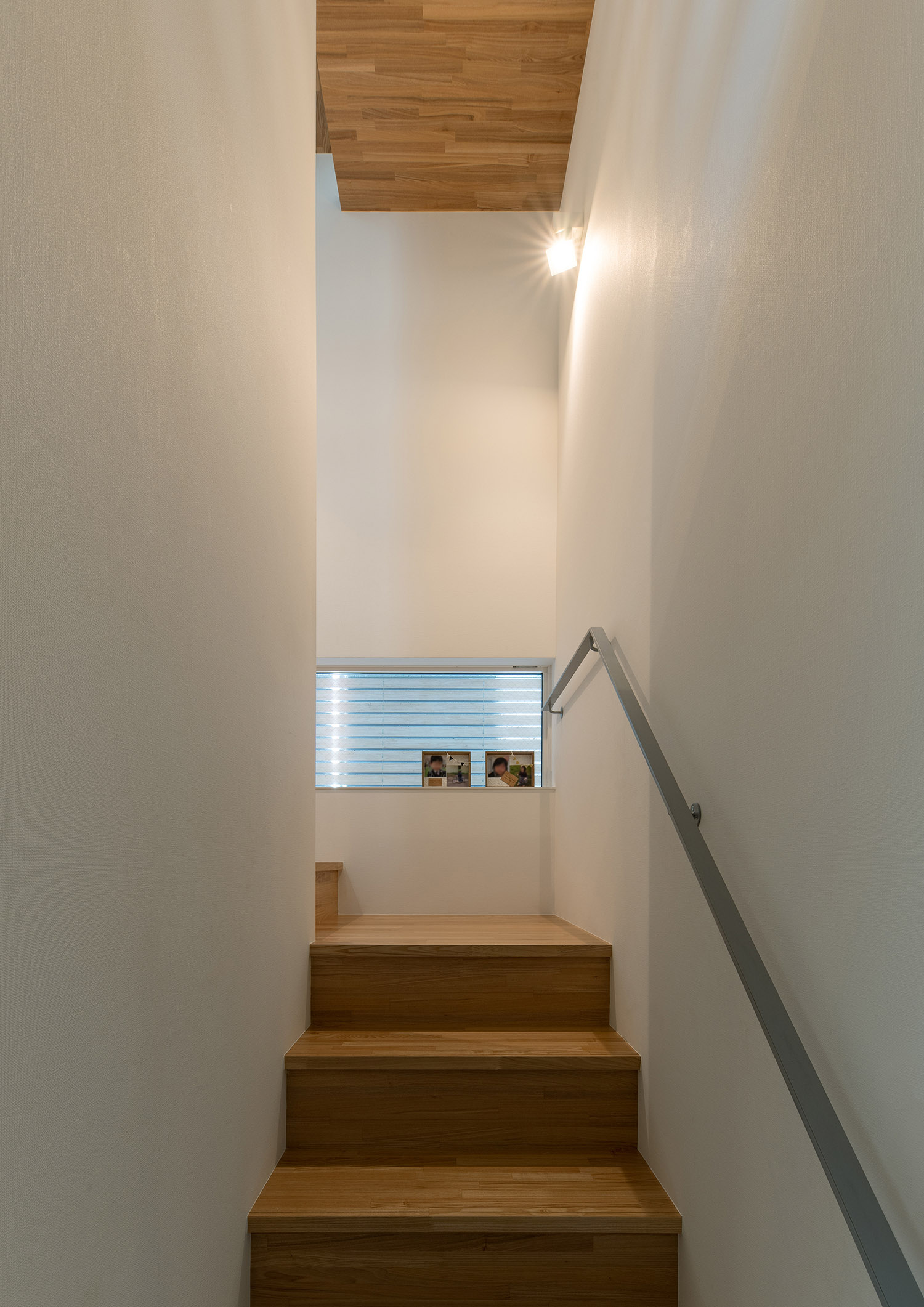 グレーの手すりが取り付けられた木製の箱型階段・デザイン住宅