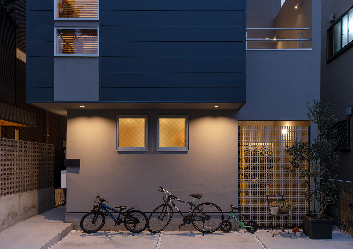 コンクリートのアプローチに自転車が2台止められた様子・デザイン住宅