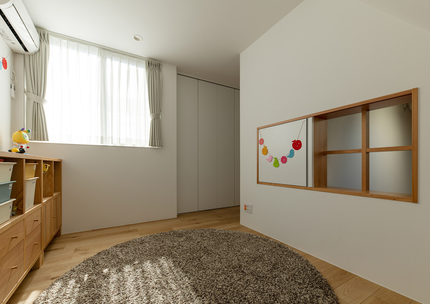 室内窓が取り付けられた、カーペットを敷いた北欧風の子供部屋・デザイン住宅