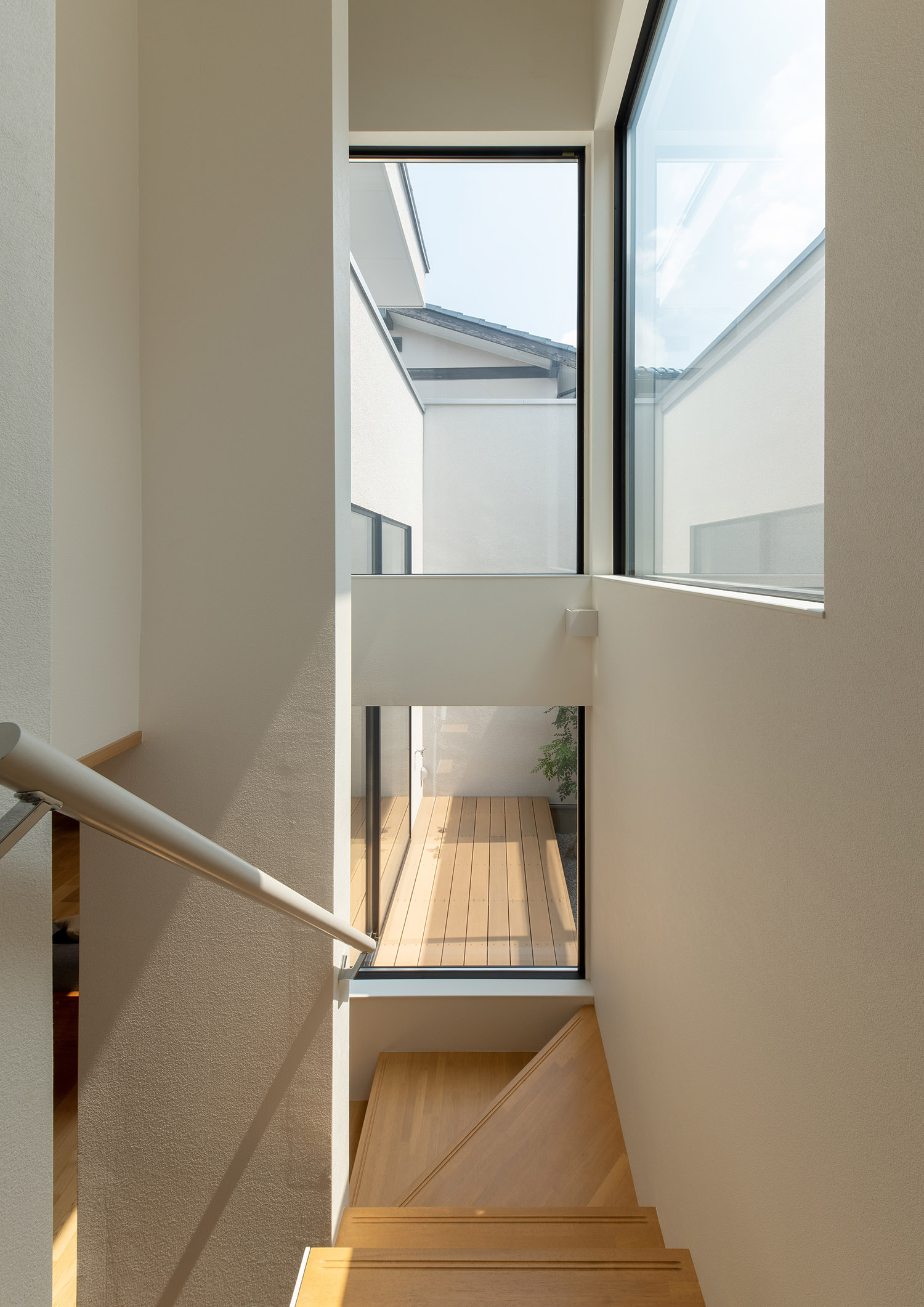 バルコニーと繋がっているように見える窓がある開放的な階段室・デザイン住宅