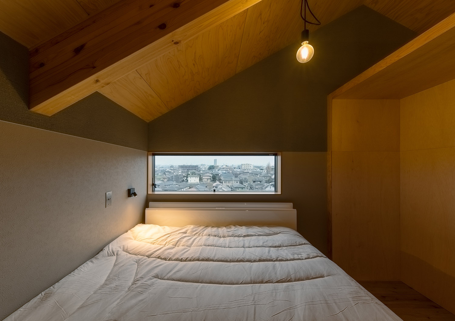 スリット窓がある、ペンダントライトを取り付けた寝室・デザイン住宅