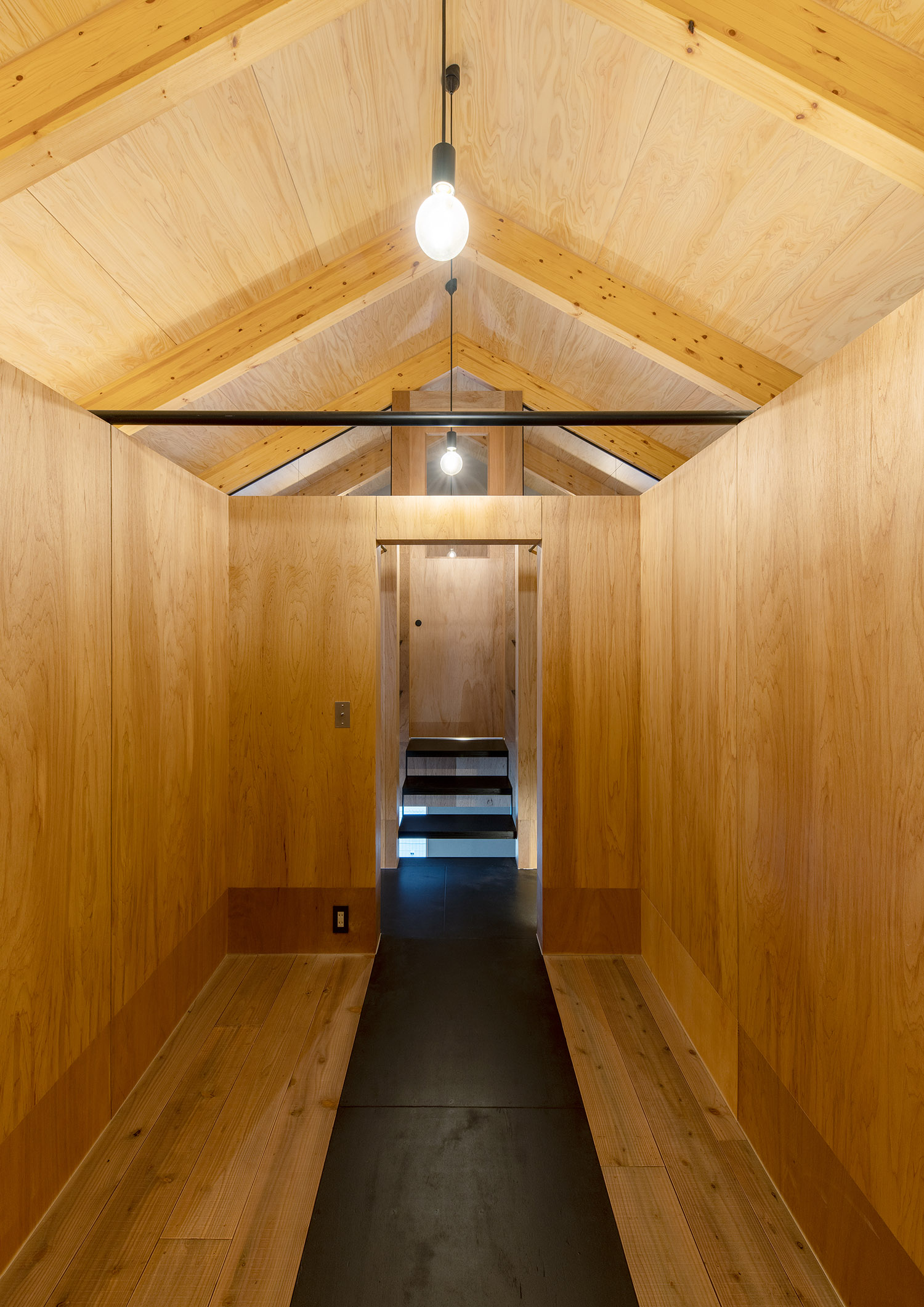木の梁見せ天井にペンダントライトを取り付けた木の壁の部屋・デザイン住宅