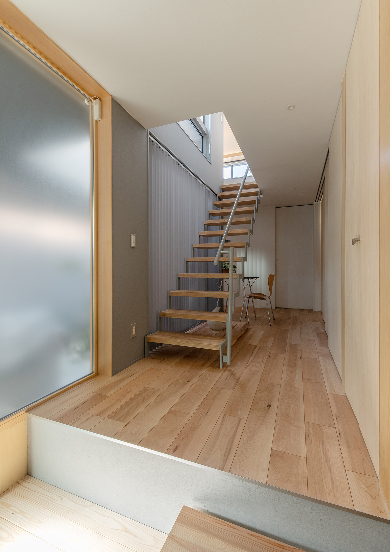 フローリングの廊下にある木製のスケルトン階段・デザイン住宅