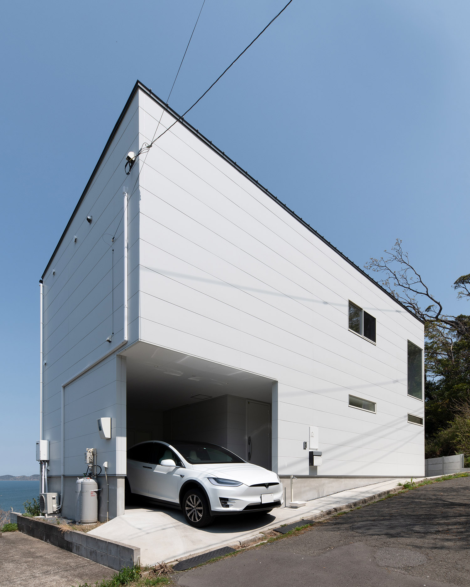 インナーガレージがある海辺に建つ白い外壁の家・デザイン住宅