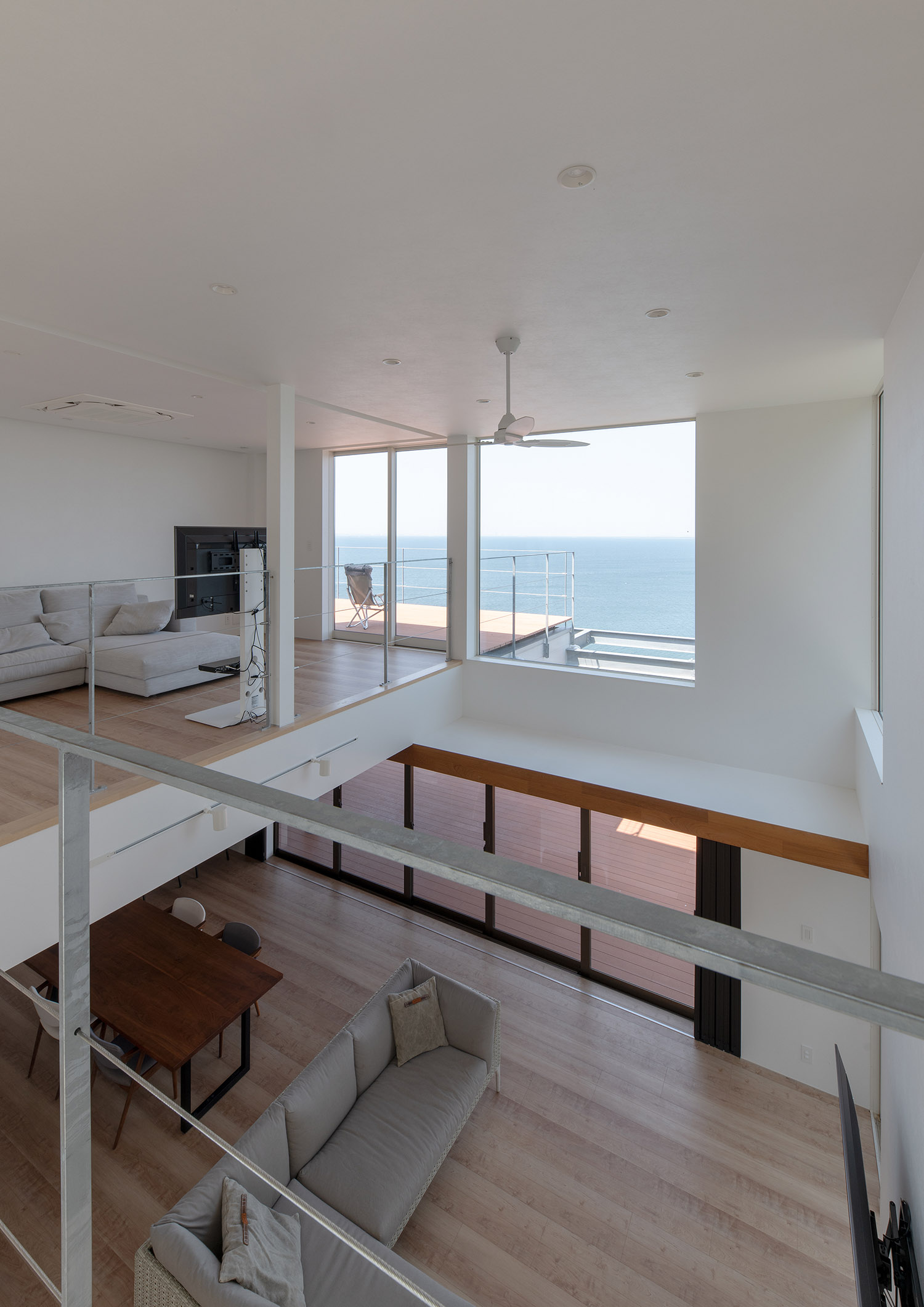 天井にシーリングファンを取り付けた、窓から海が見える開放的なLDK・デザイン住宅