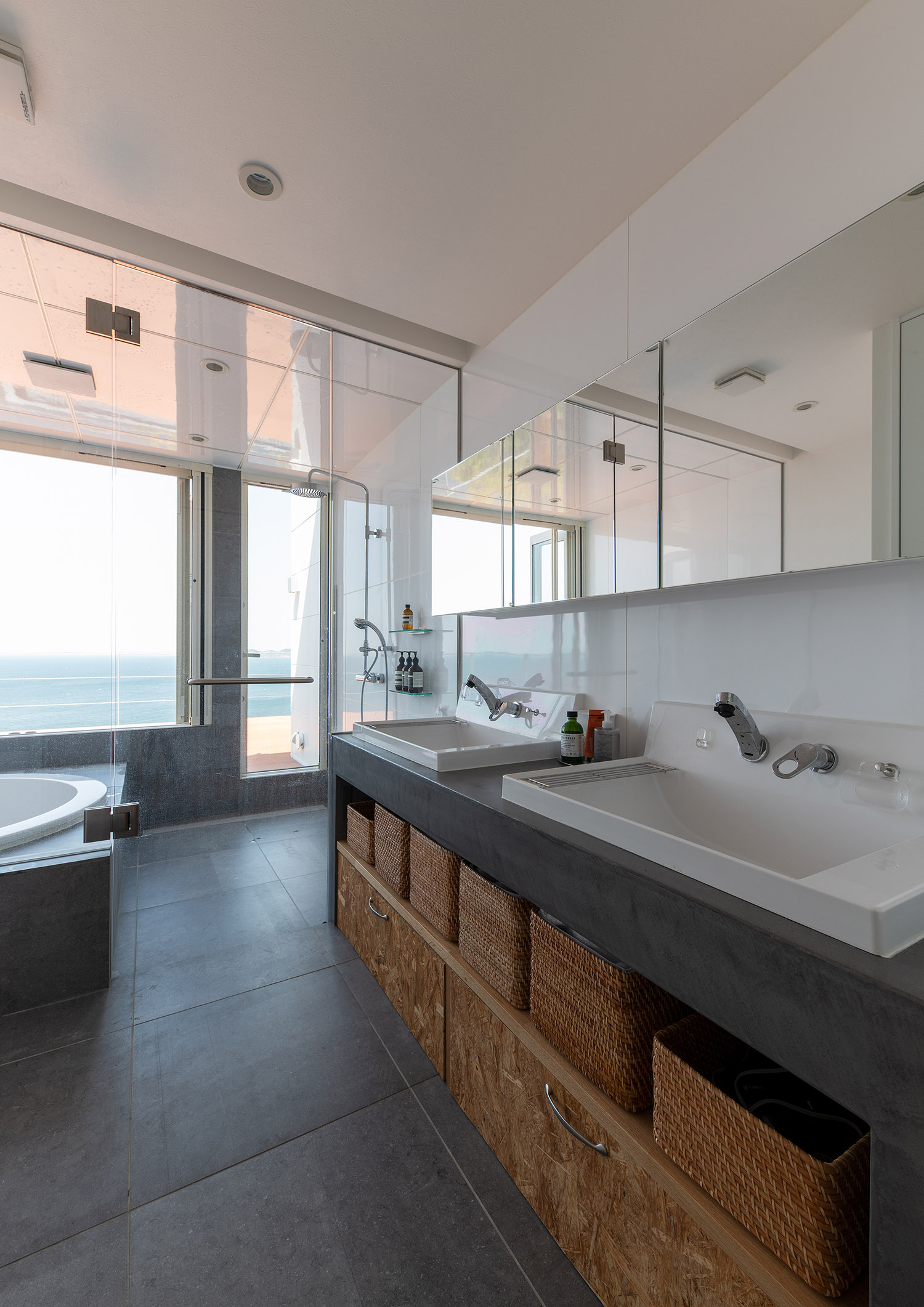 浴室とガラス扉で仕切られたダブルボウルの洗面所・デザイン住宅