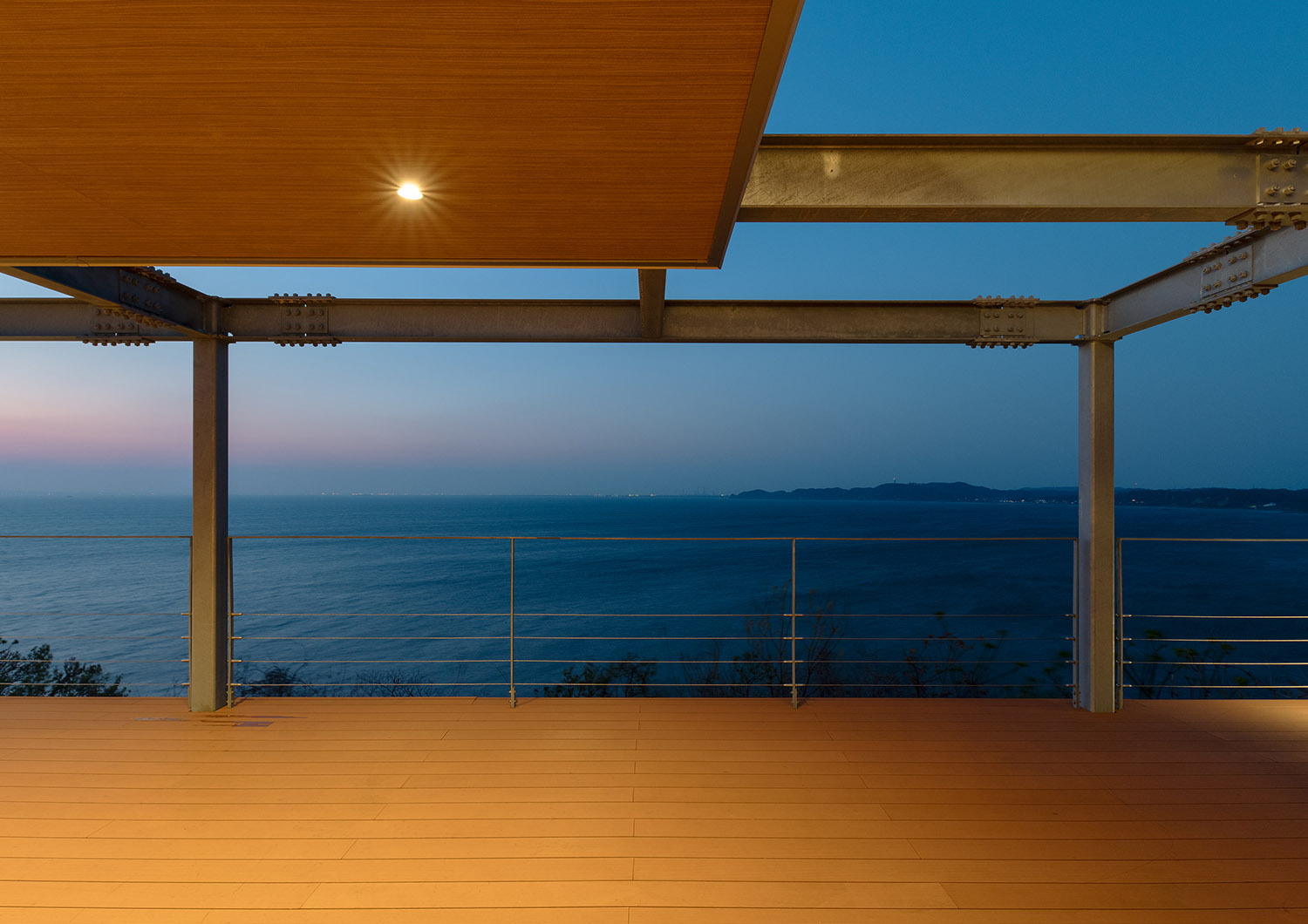 木目の軒天井にダウンライトを取り付けた海を見渡せるバルコニー・デザイン住宅